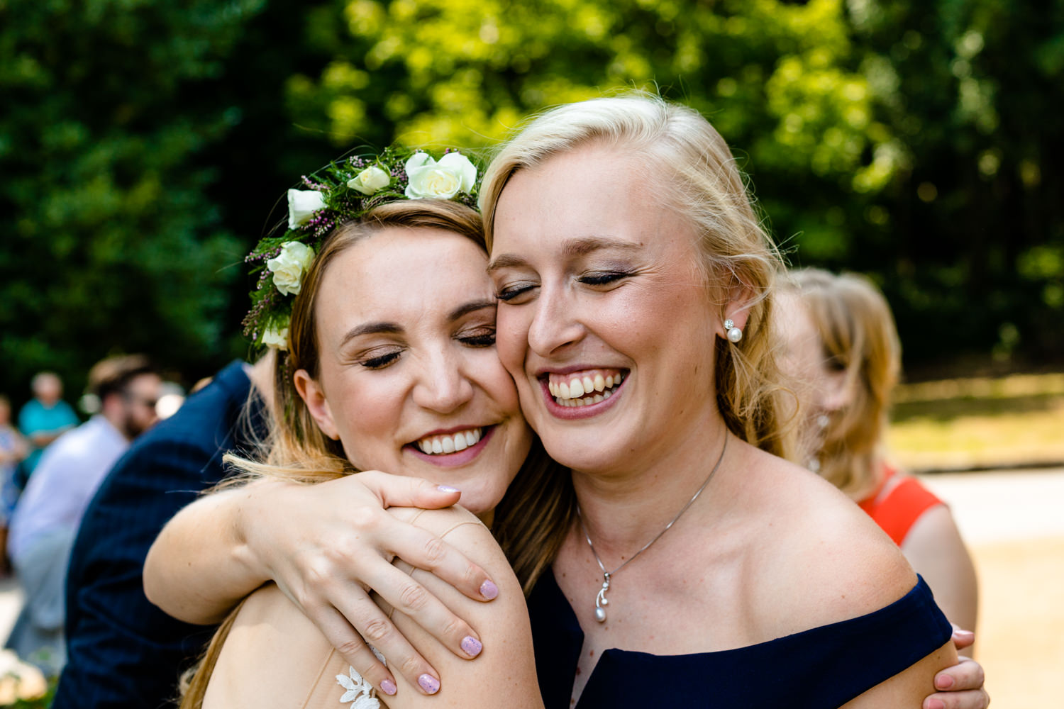 A bride and bridesmaid hug, wedding photograph Whirlowbrook Hall