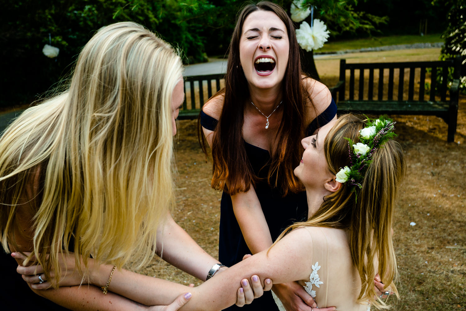 Bridesmaids laugh as they drop the the bride. 