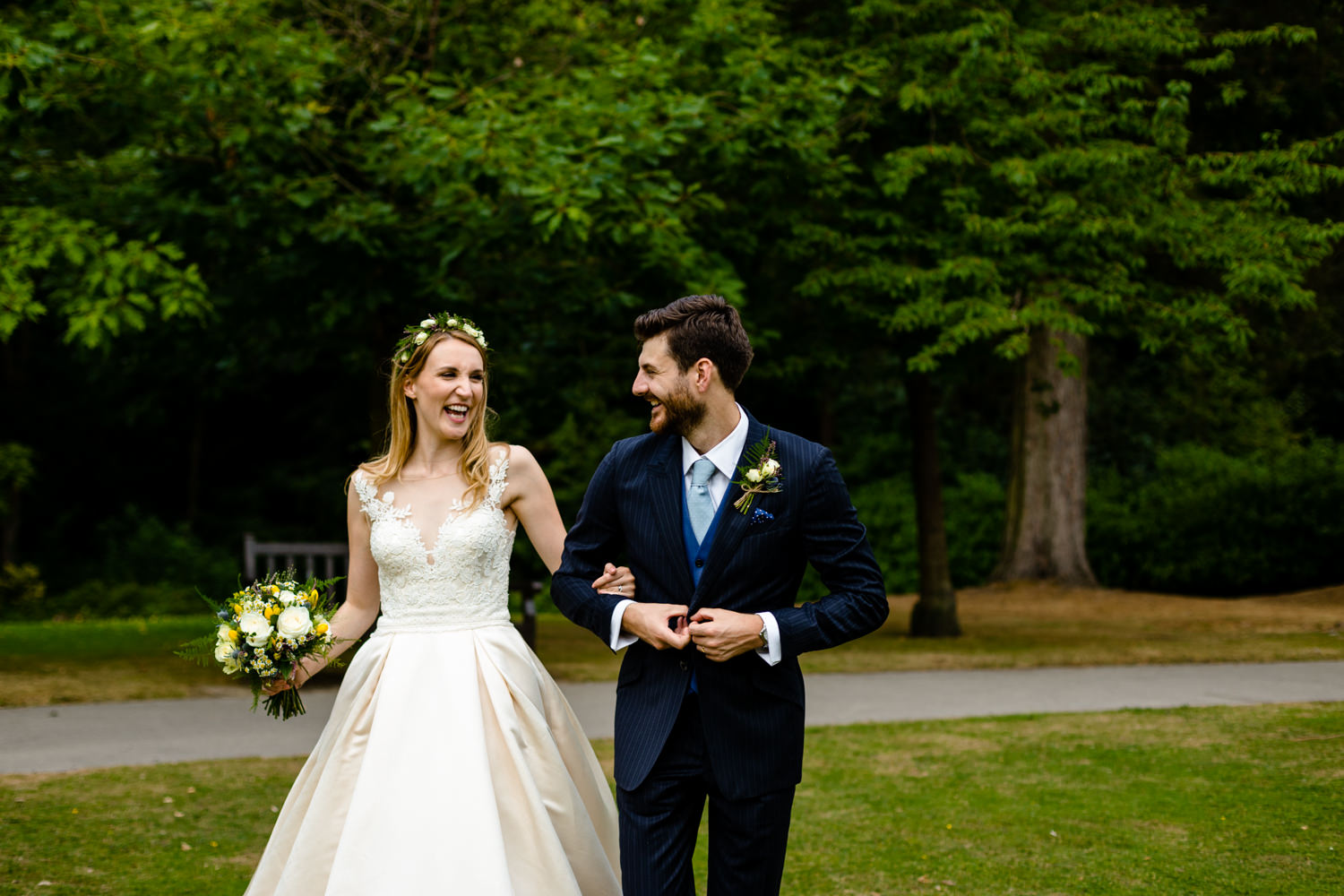 A bride and groom laughing as they walk, Whirlowbrook Hall	Sheffield wedding photography