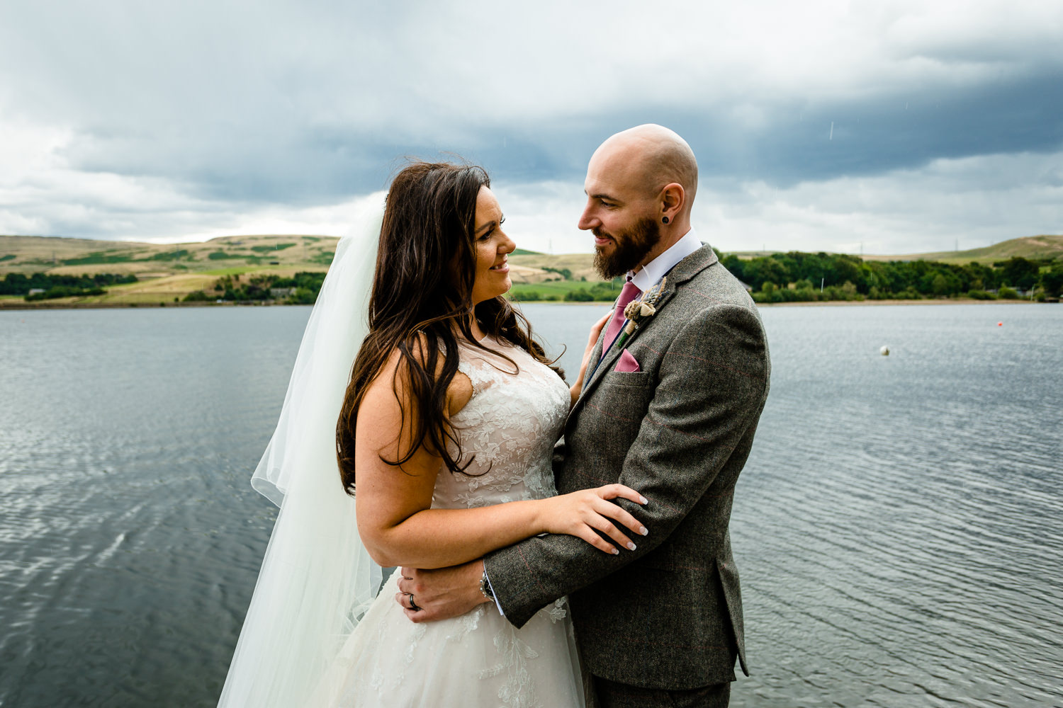 wedding photographer Rochdale, a bride and groom by Hollingworth Lake in the rain