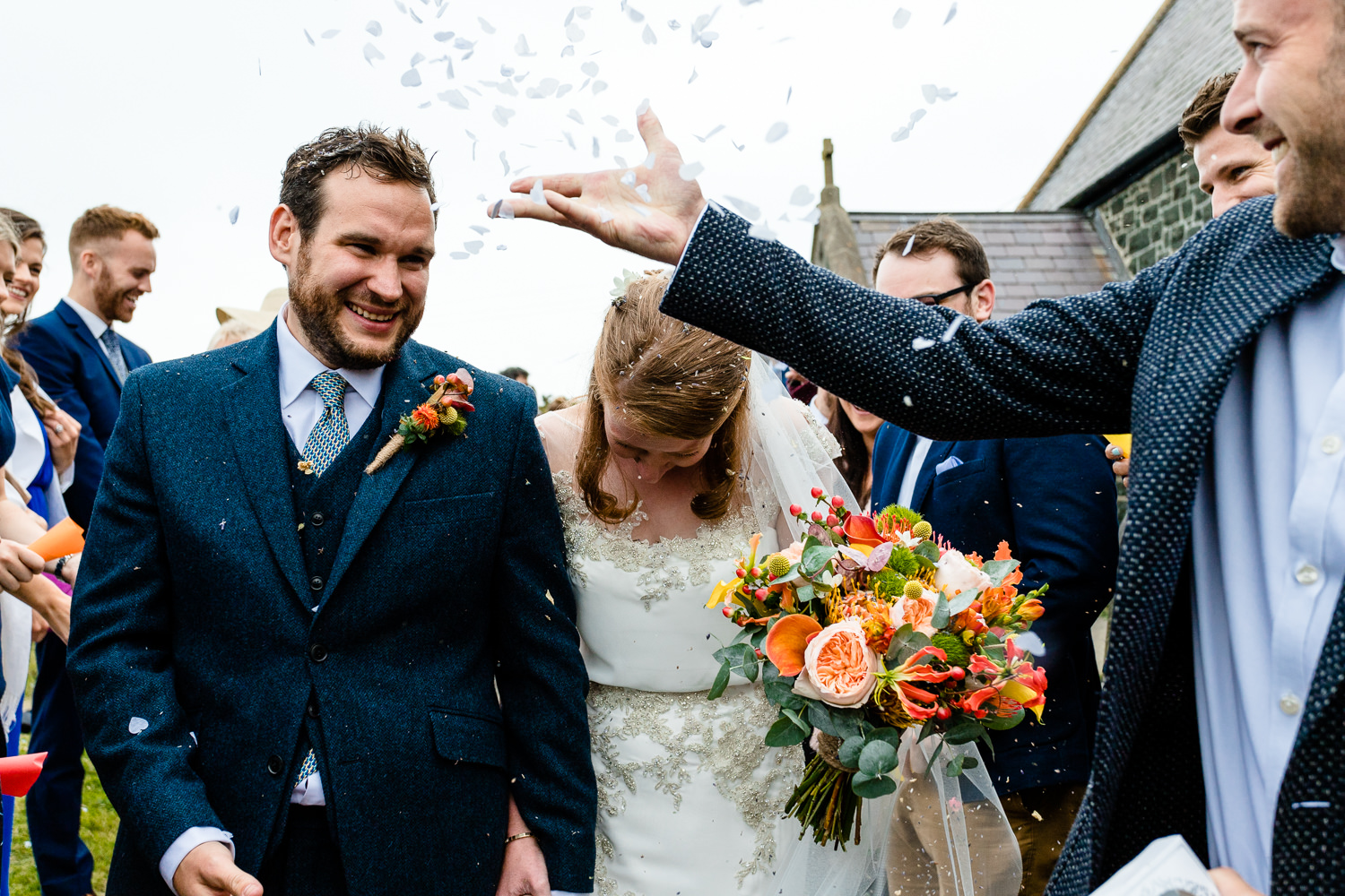 Confetti being thrown at a bride and groom, Colourful	Anglesey wedding photography