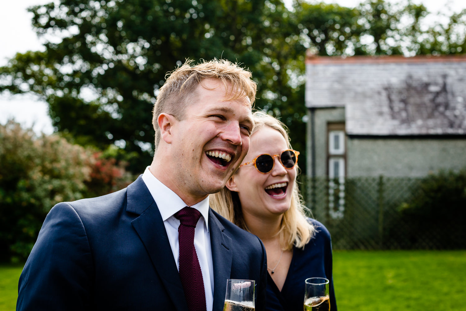 relaxed	Anglesey wedding photograph of guests laughing