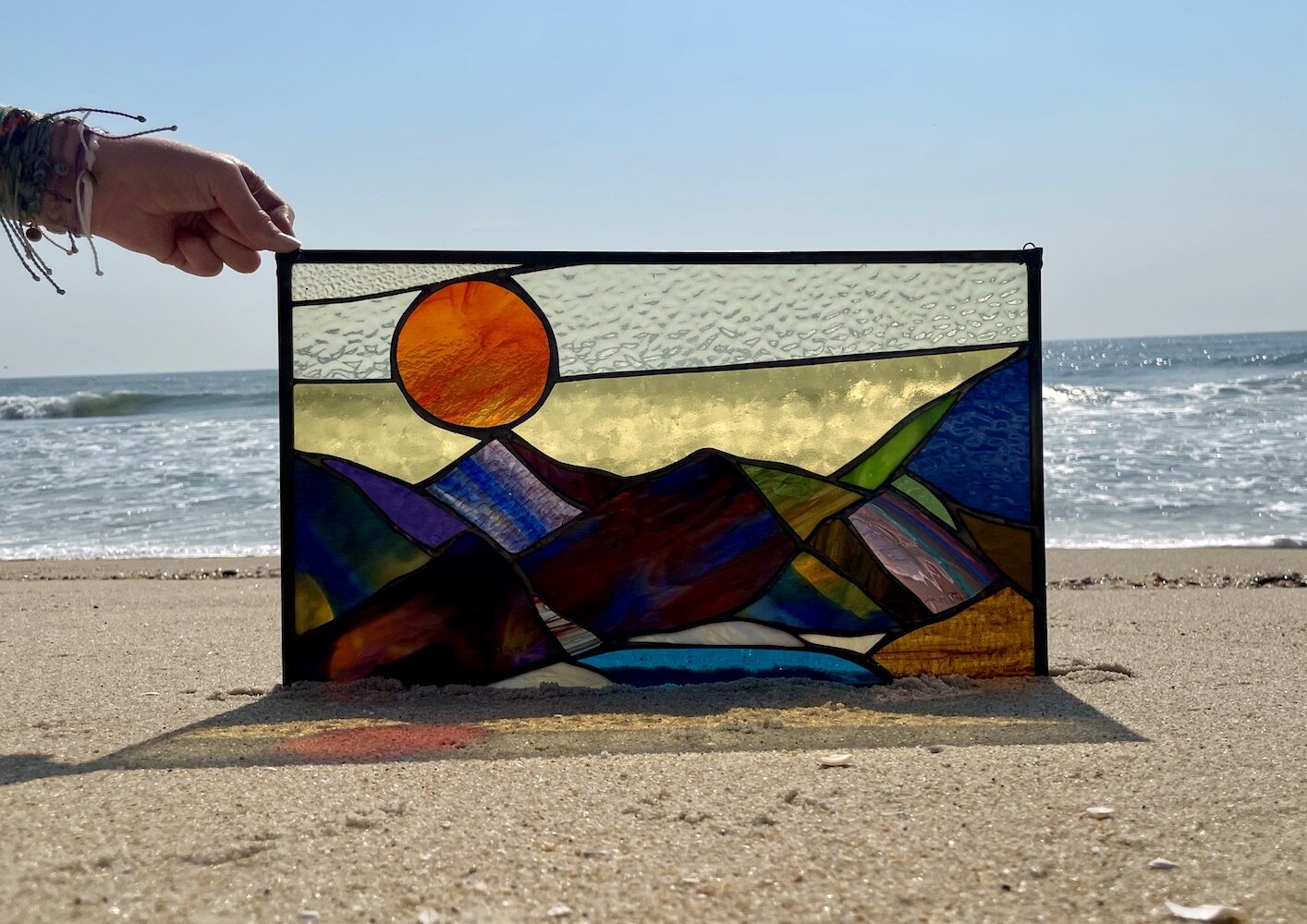 red sun over mountains stained glass window