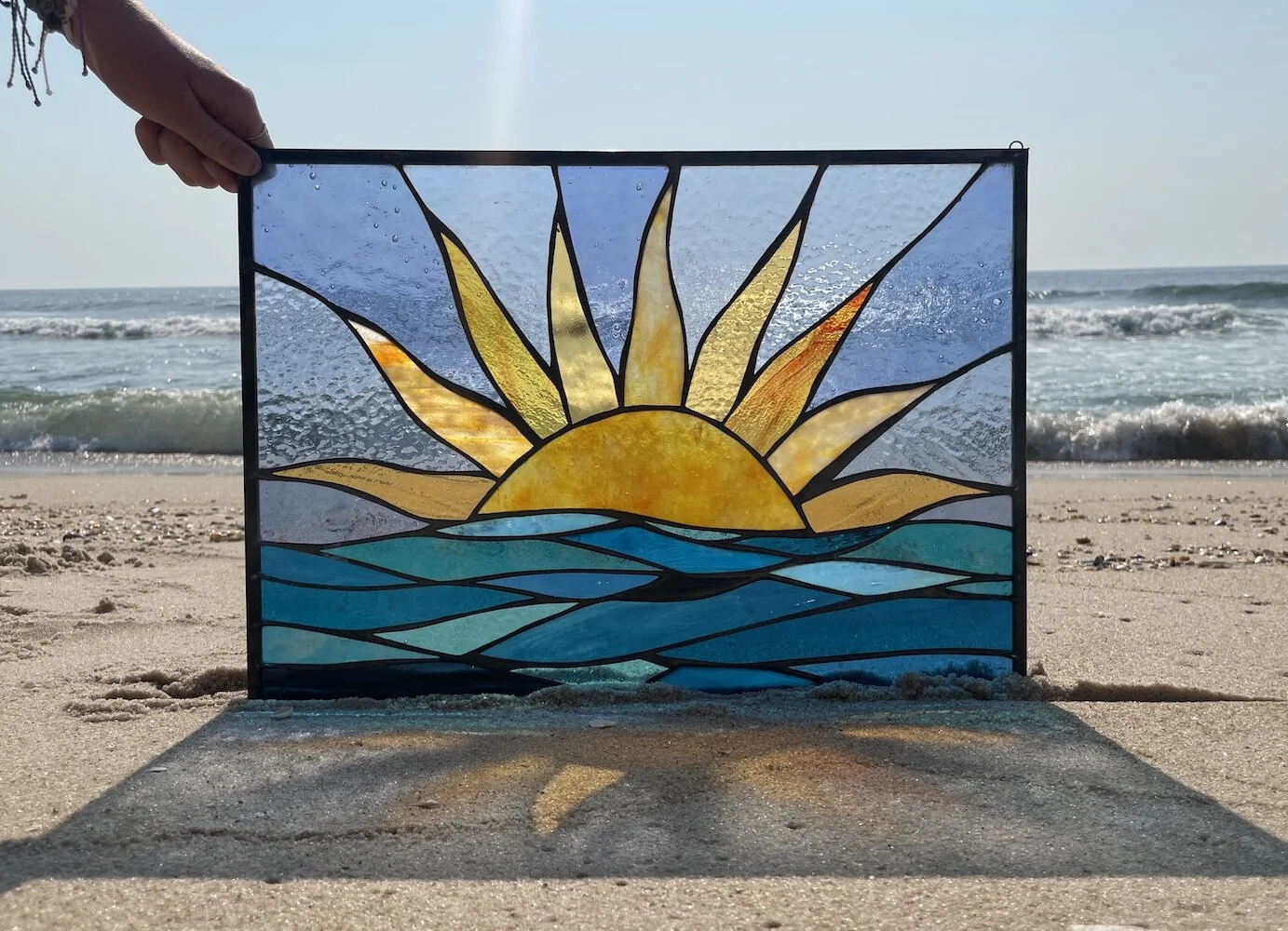 yellow sunrise over water stained glass