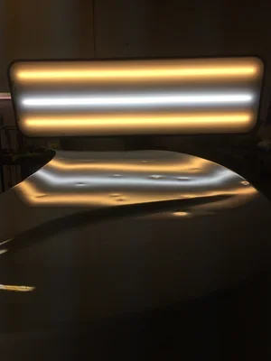 Illuminated modern chair with horizontal glowing light strips on backrest and seat.