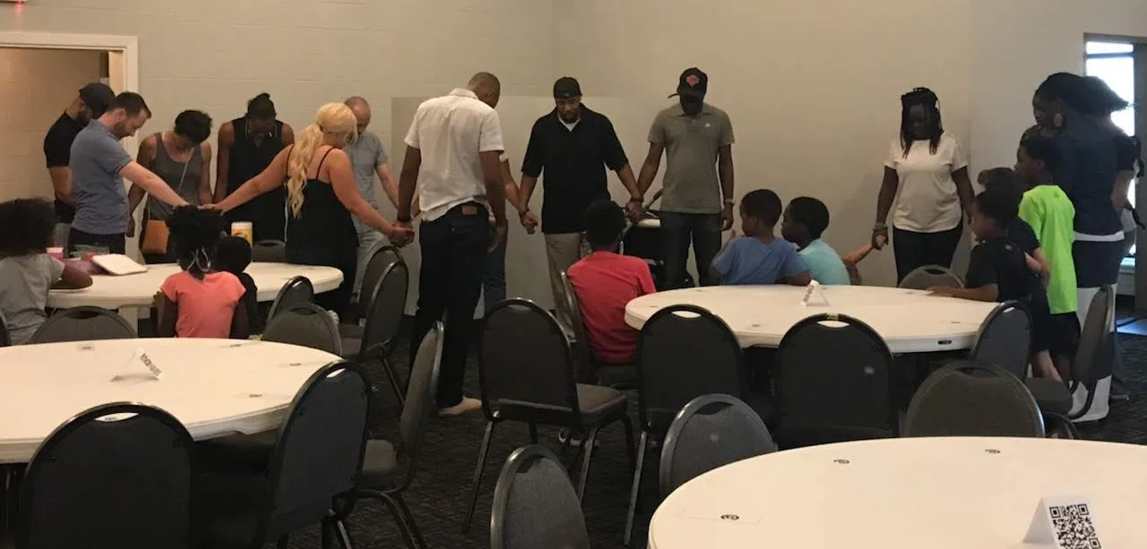 Kaynenn leading the set-up team in prayer before the info/prayer meeting.