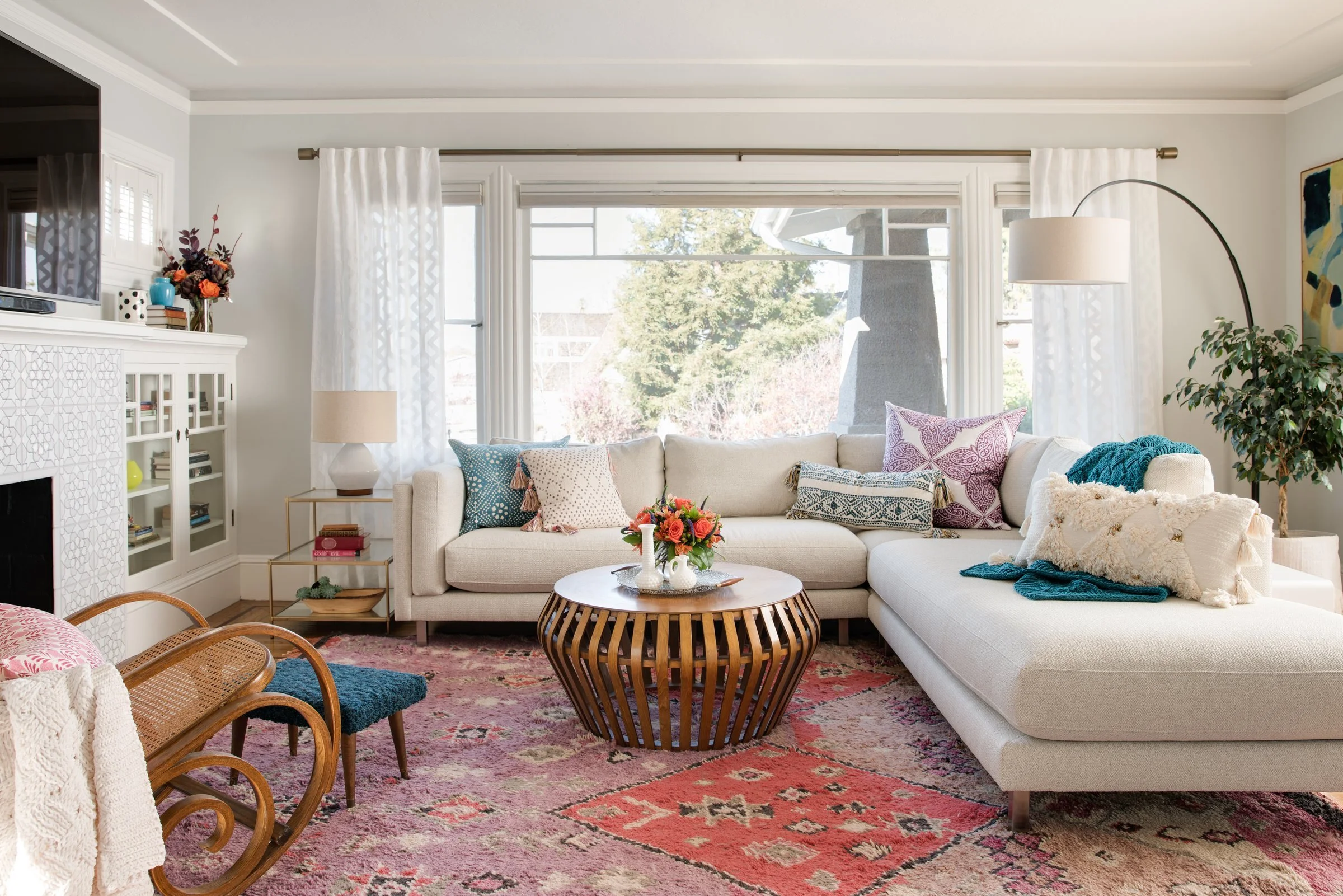 Light-filled living room with a white sectional and layered rugs, designed by JL Interior Design
