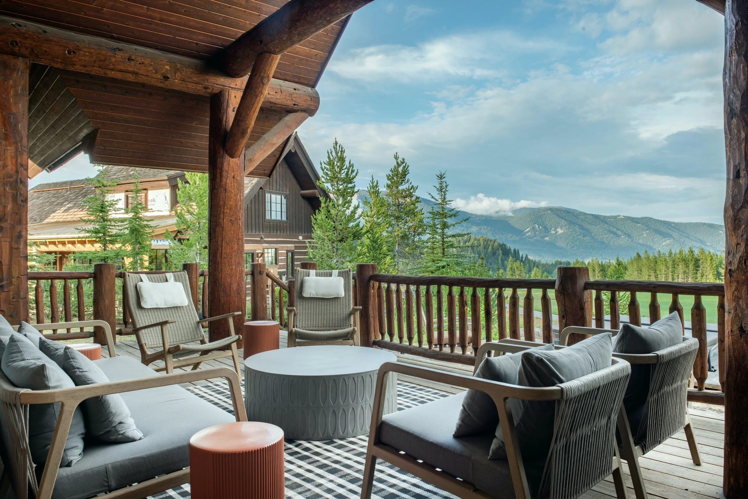 Covered mountain deck with outdoor seating and a view of the peaks, JL Interior Design