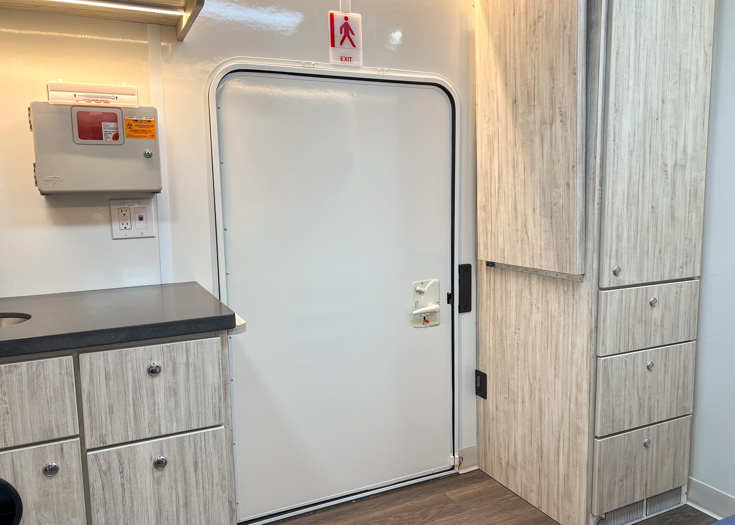  Handicap accessible door (with wheelchair lift on outside), sink area (left), storage (right), and work surface stowed. 