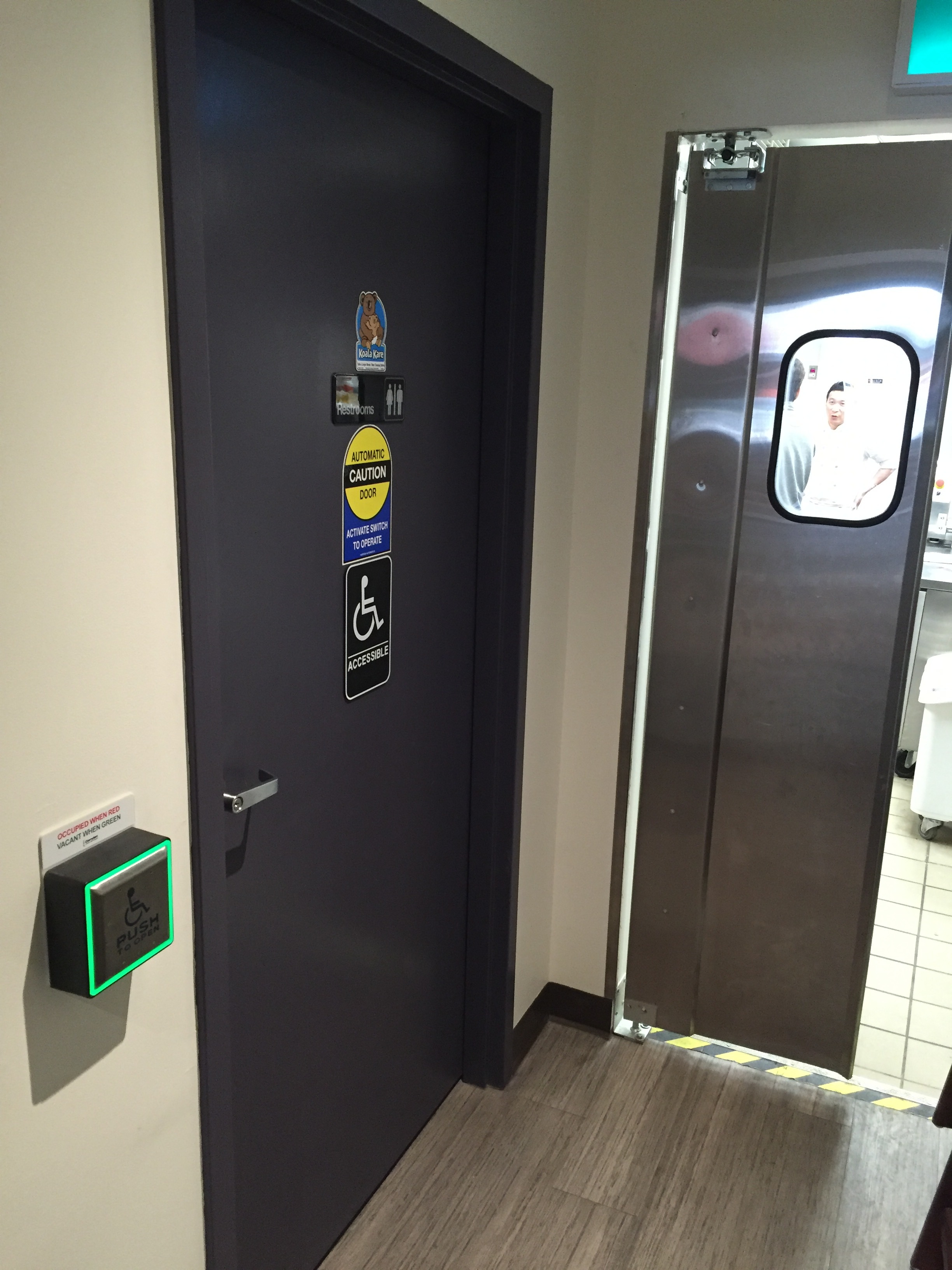 Picture of entrance of accessible washroom. Automatic push button to the left.