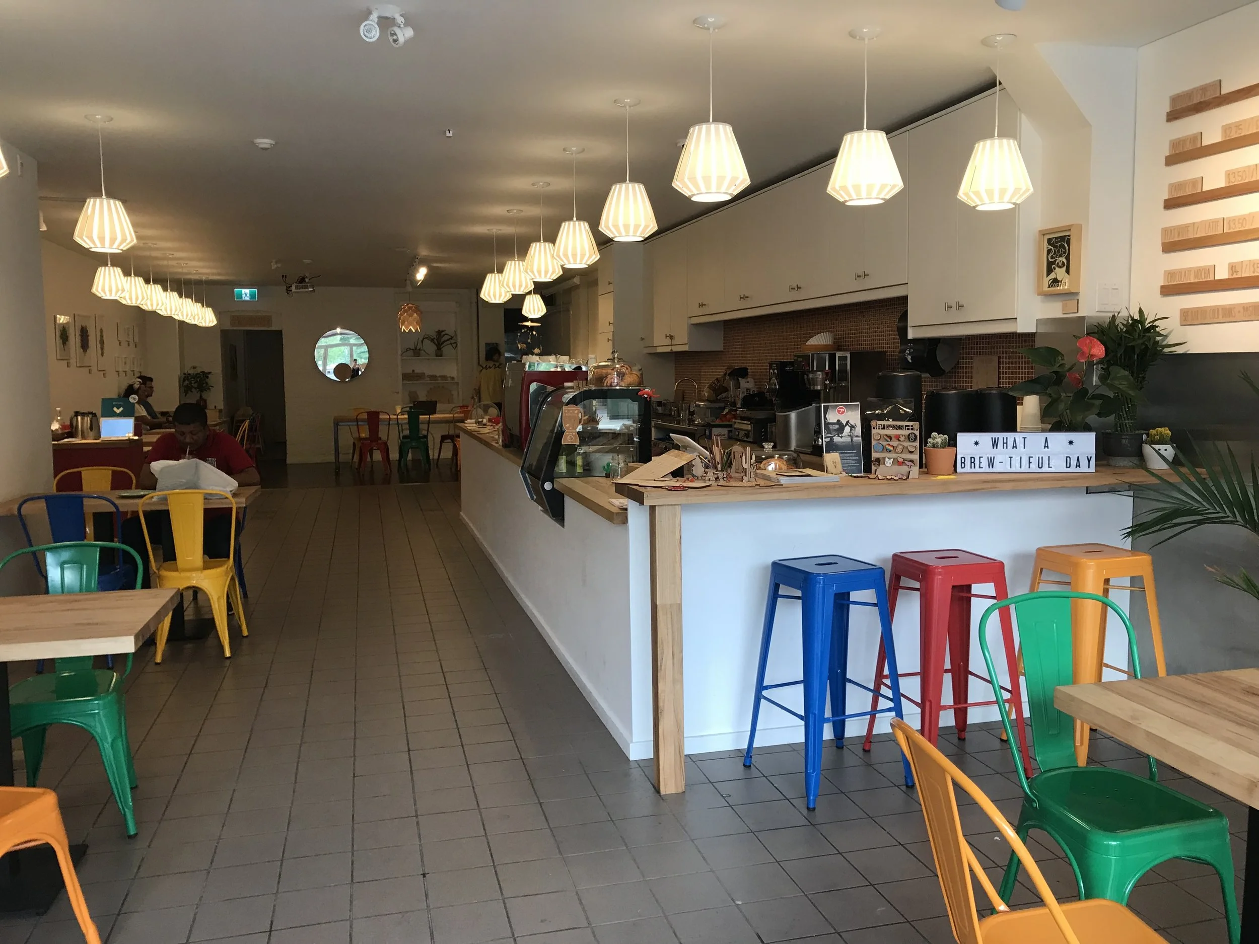 Picture of wide interior and standard height tables of Maker Bean Cafe