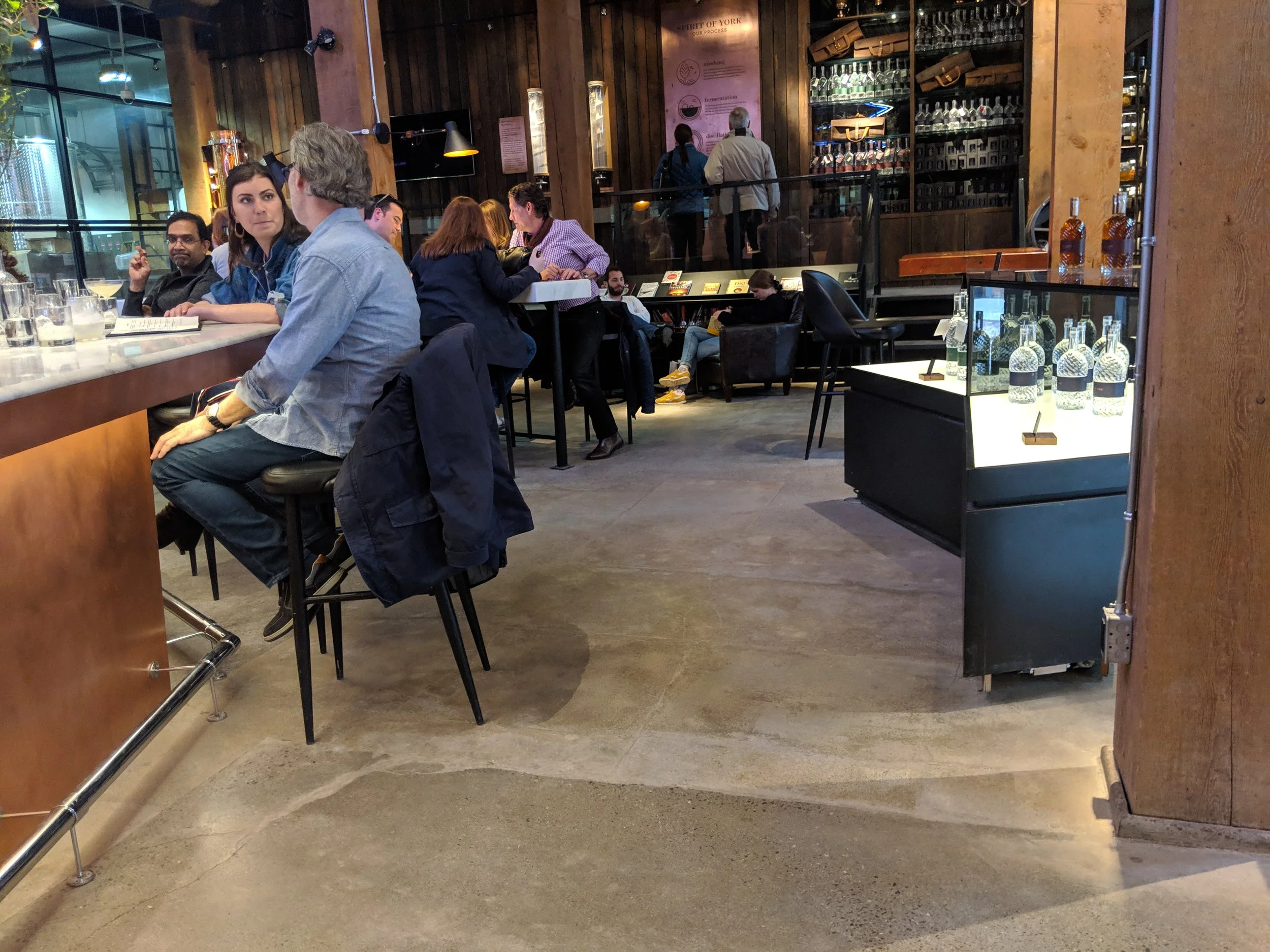 Picture of people chatting at the bar at Spirit of York. Bar height tables on display