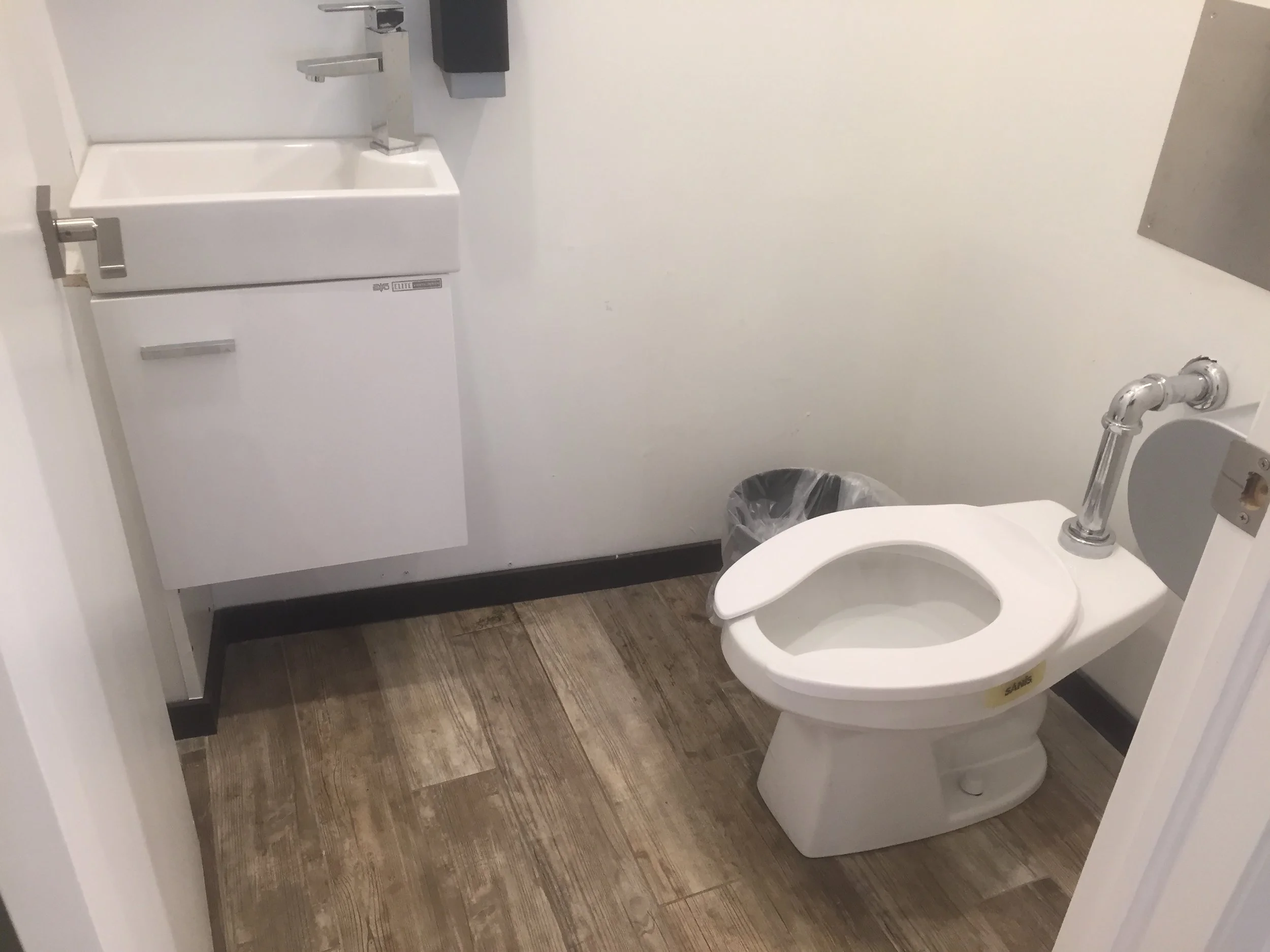 Picture of interior of washroom with no grab bars and small sink