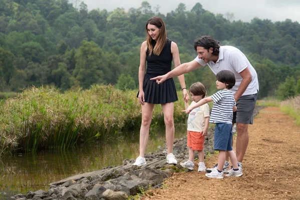 Familia caminando junto al lago rodeada de naturaleza