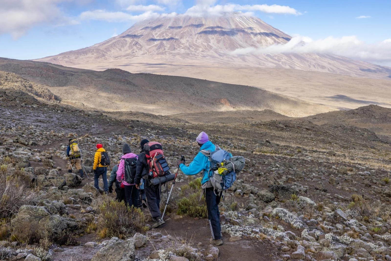 A group of hikers, trek up the rocky paths of Kilimanjaro