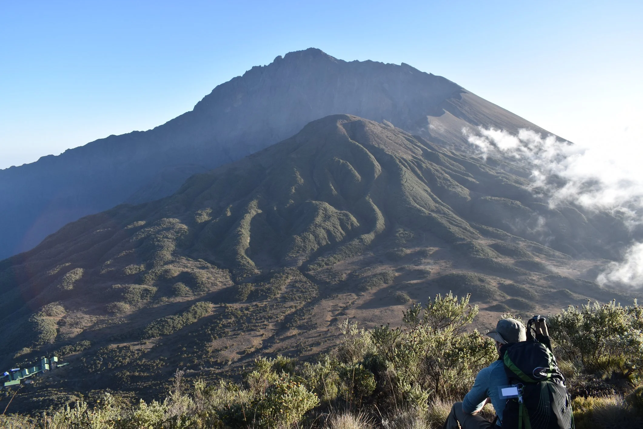 A hiker staring up at the summit of Mount Meru