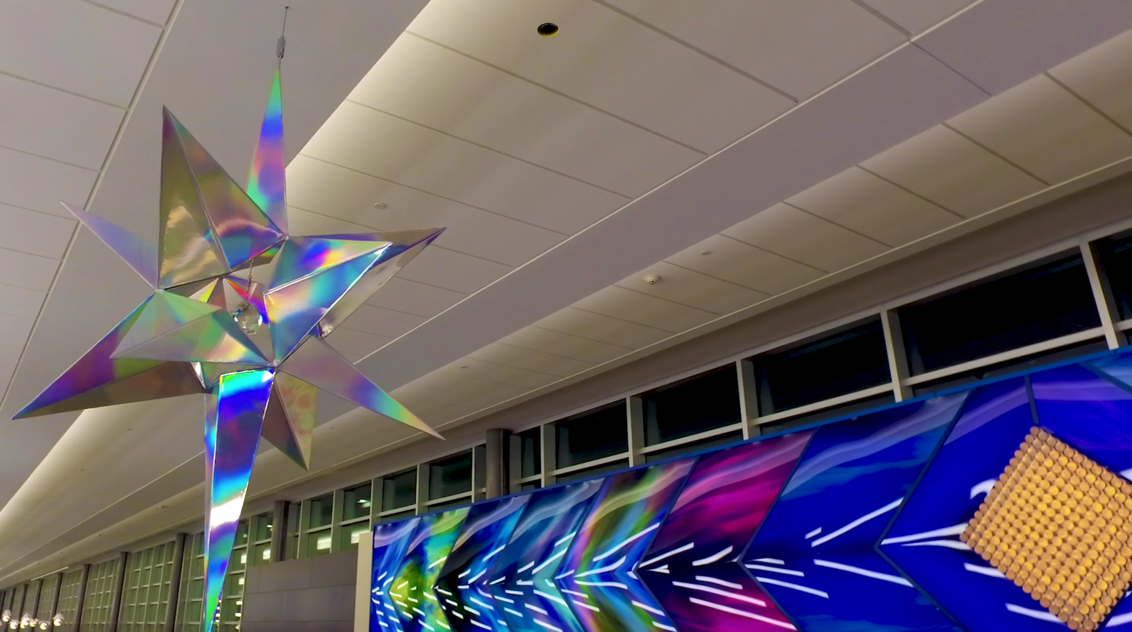 This artwork is based on the Minnesota state motto, “ L'Etoile du Nord" (Star of the North) is based on the Minnesota State Motto that was first adopted in 1861 and is on our state seal. L'Etoile du Nord is 6 feet tall, made of aluminum and covered with holographic rainbow vinyl. Inside the star is a crystal prism that is lit so tiny light rainbows show on the ground below the star. L'Etoile du Nord uses rainbows to both be visually beautiful, but also to impart the meaning that anybody of any race, creed, nationality or sexual orientation are welcome in Minnesota,.