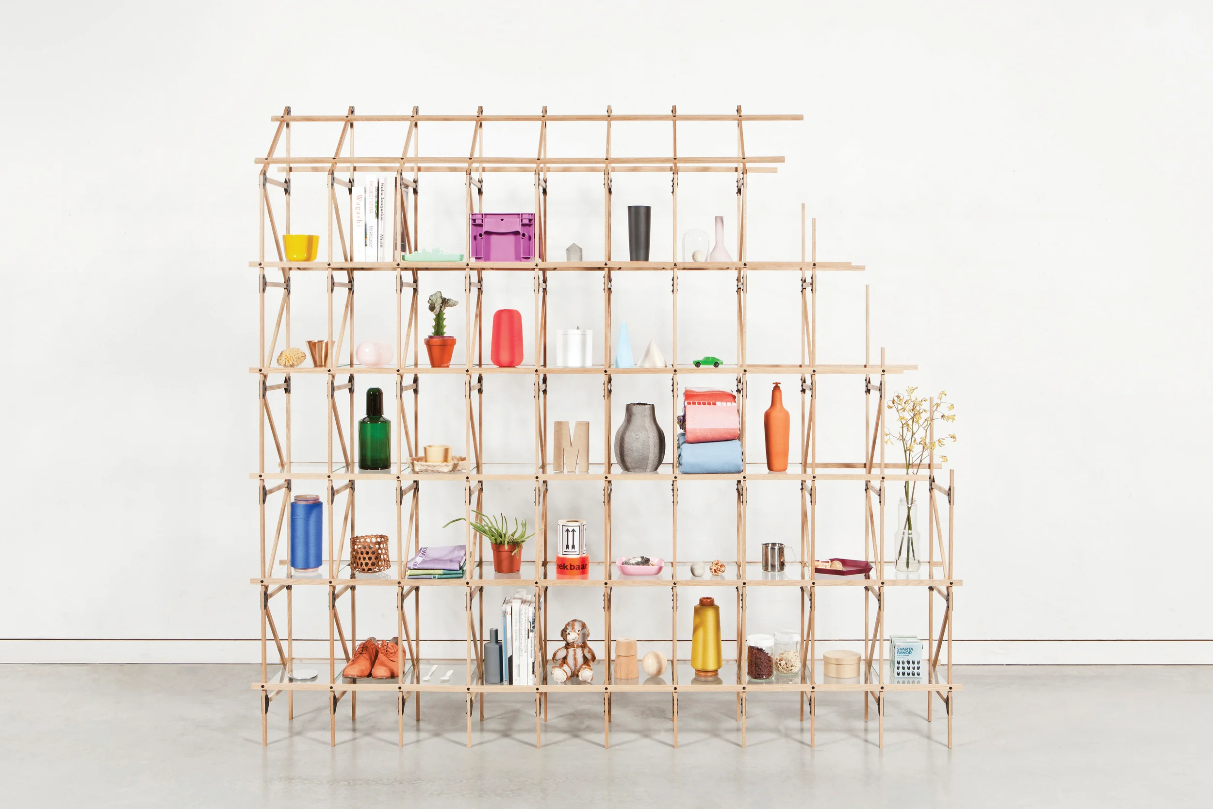 The system consists of thin oak slats connected by steel plates and rivets. The addition of glass shelves creates a storage function in which the transparent, light-weight nature of the design is reinforced. The functional, elegant and industrial character of it is typical of the work of Studio Mieke Meijer.