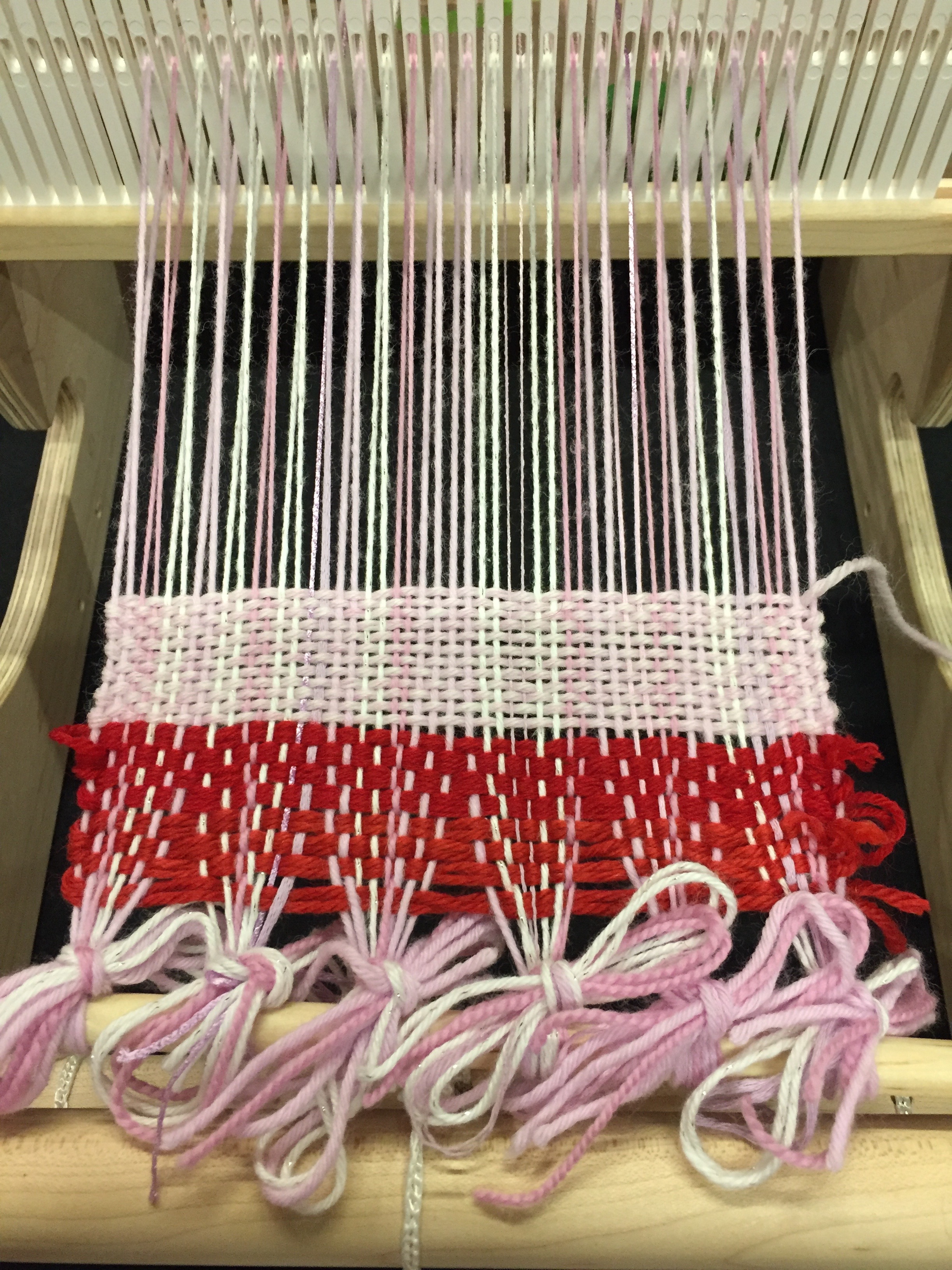 the red yarn is waste yarn that separates the warp so it is evenly spaced; the pink yarn is my first few rows!