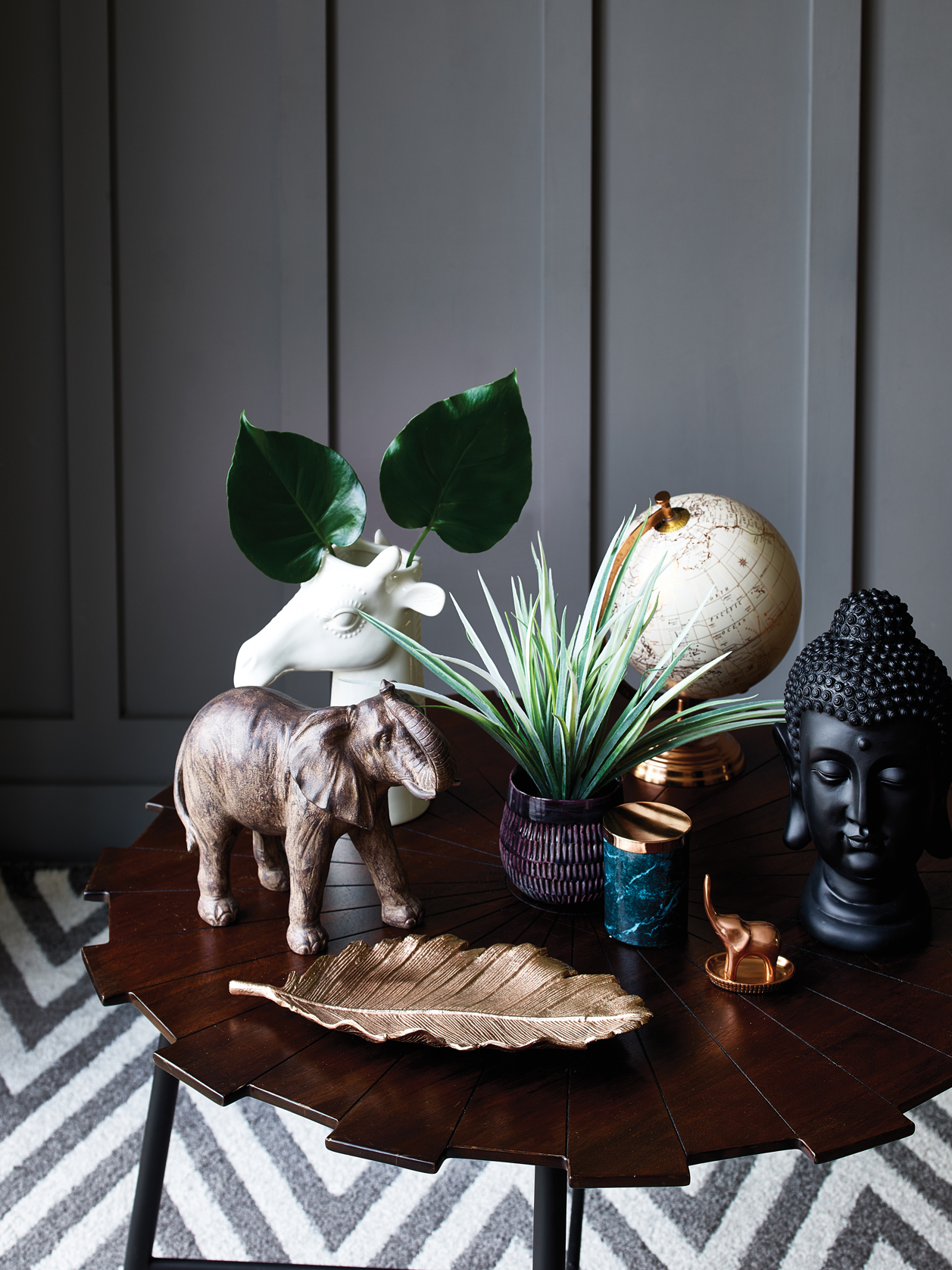 Elephant ornament - £15, Giraffe vase - £12, Copper globe - £15, Purple potted grass - £8, Marble print candle - £4, Buddha ornament - £12, Copper leaf plate - £12, Starburst coffee table - £79, Homemaker grey chevron rug - £60.