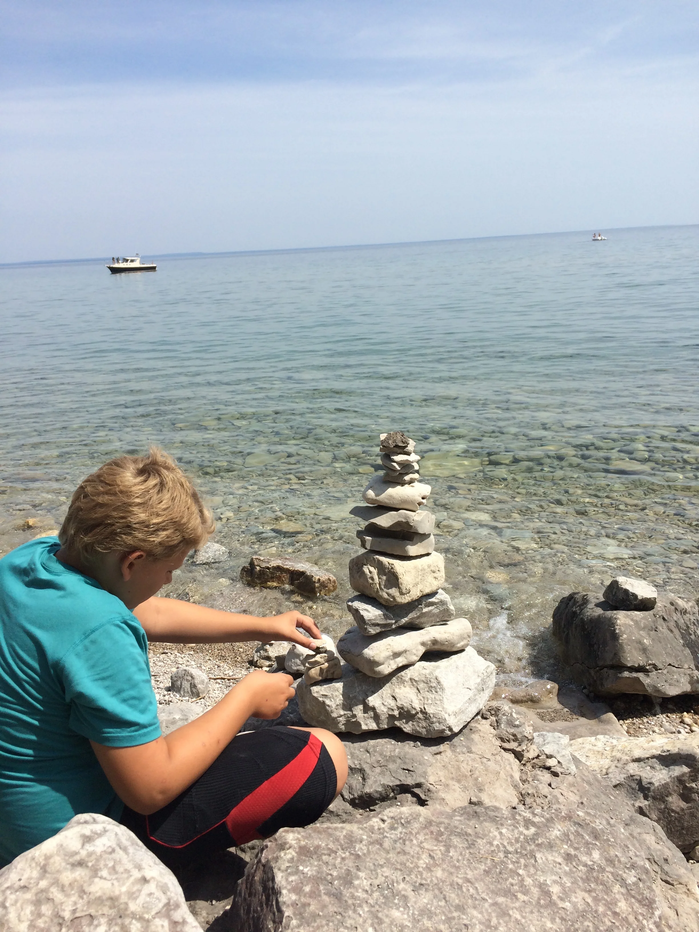 Cairn building on the shores of Lake Michigan can be an hours-long pastime for this guy who takes the world in deeply.