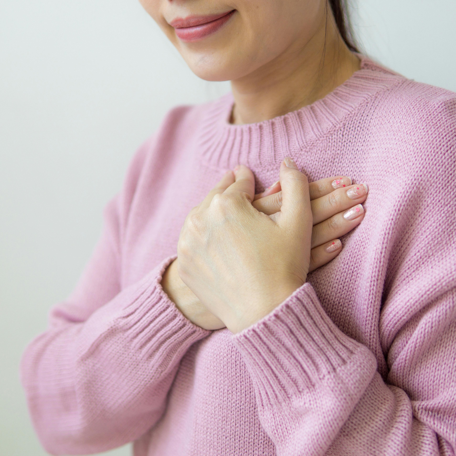 A woman resting her hands over her heart