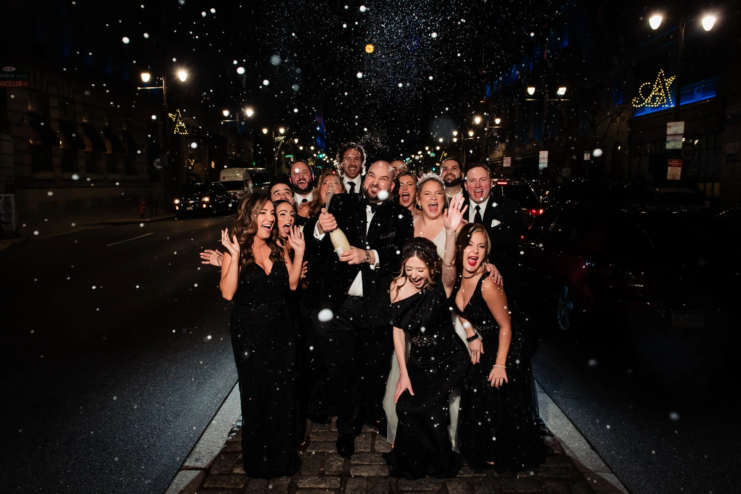 Kelly and Greg's wedding party on the street at night outside The Lucy