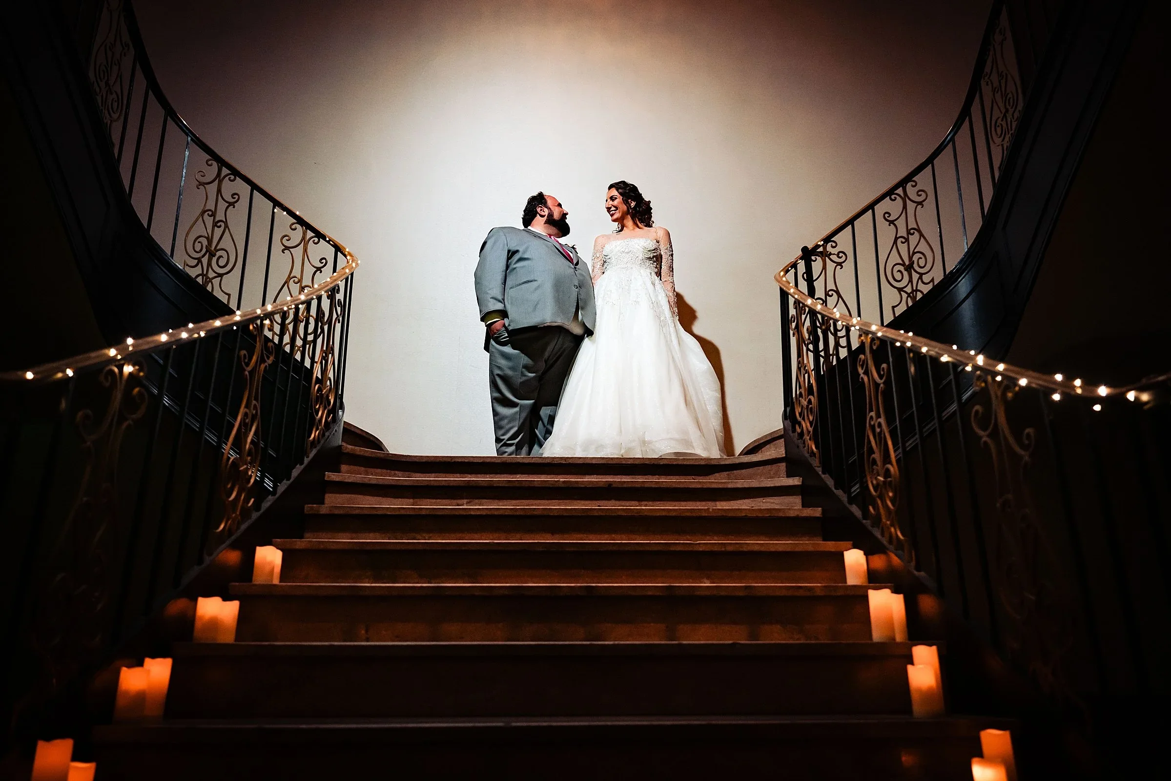 Couple at the top of the candlelit staircase at Ballroom at the Ben