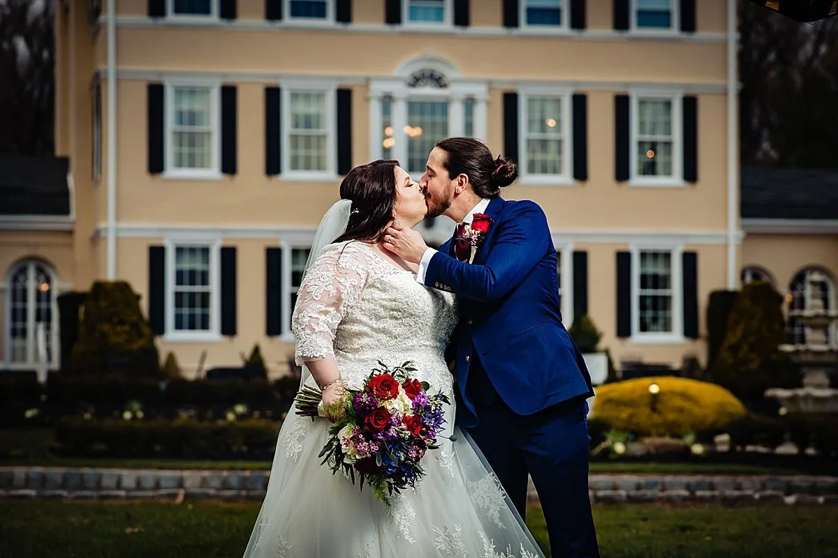 Couple kissing in front of the estate house at Pen Ryn Estate