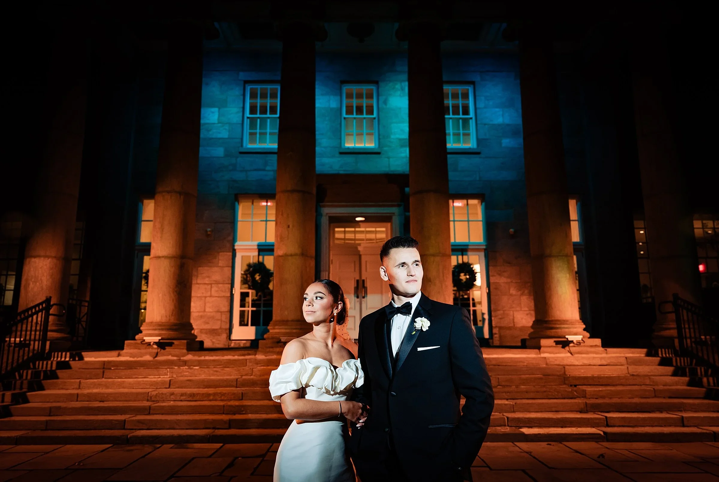 Gianna and Andrew on the steps at night at Ballroom at Ellis Preserve