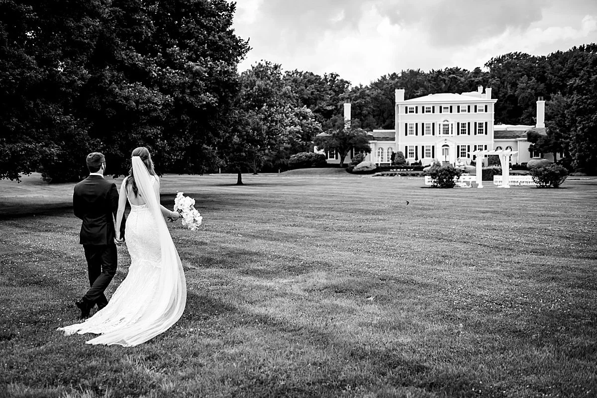 Couple walking across the lawn toward the Pen Ryn Mansion