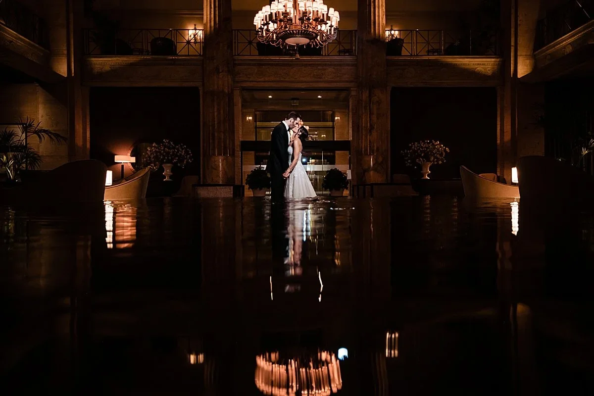 Couple standing in the dark ballroom, reflected in the floor, at Ballroom at the Ben