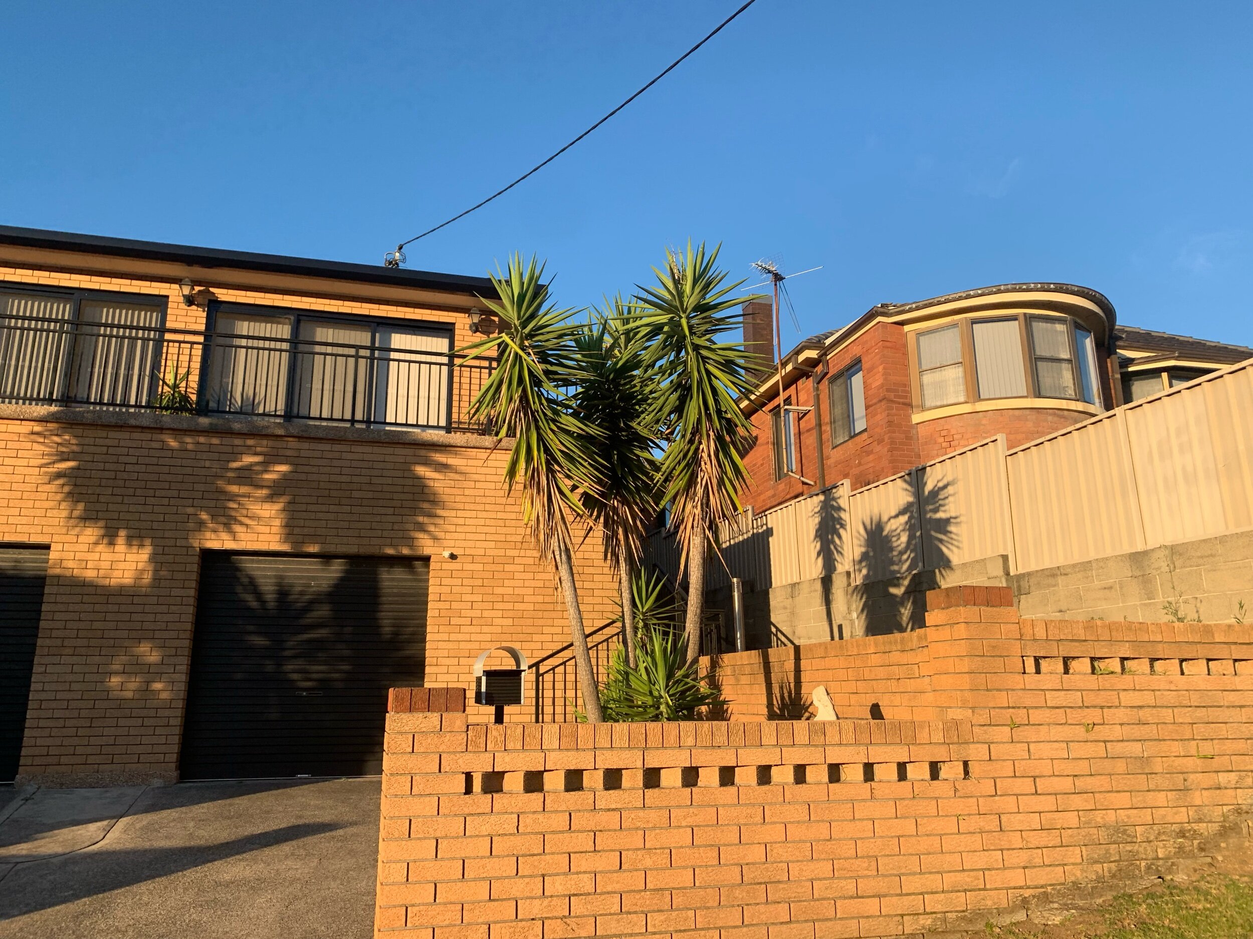 A great mixture of brown brick, glass, plants, shadows, aluminum, and yes blue skies. 