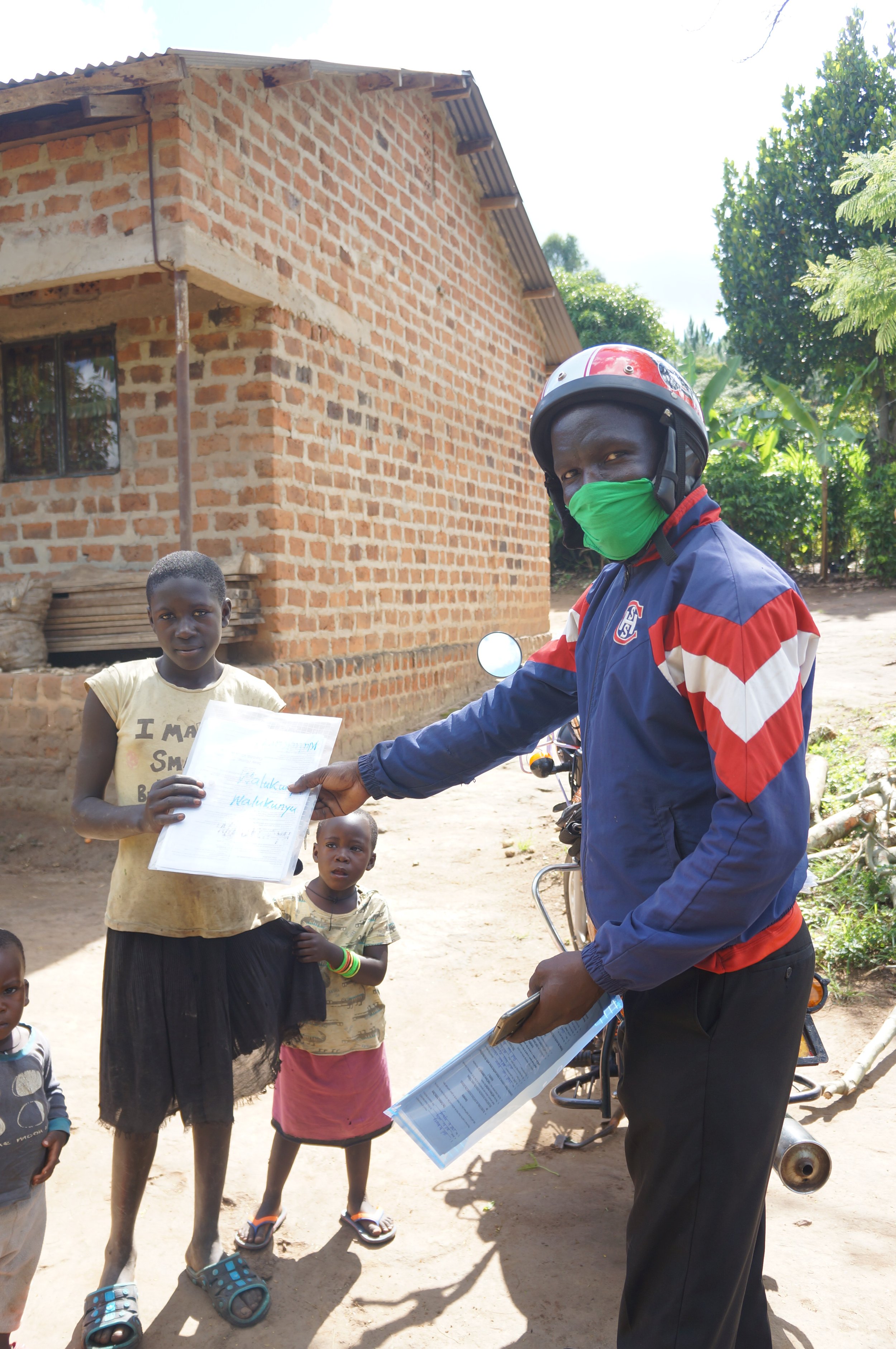 Robinah Nakate delivering homework pack.JPG