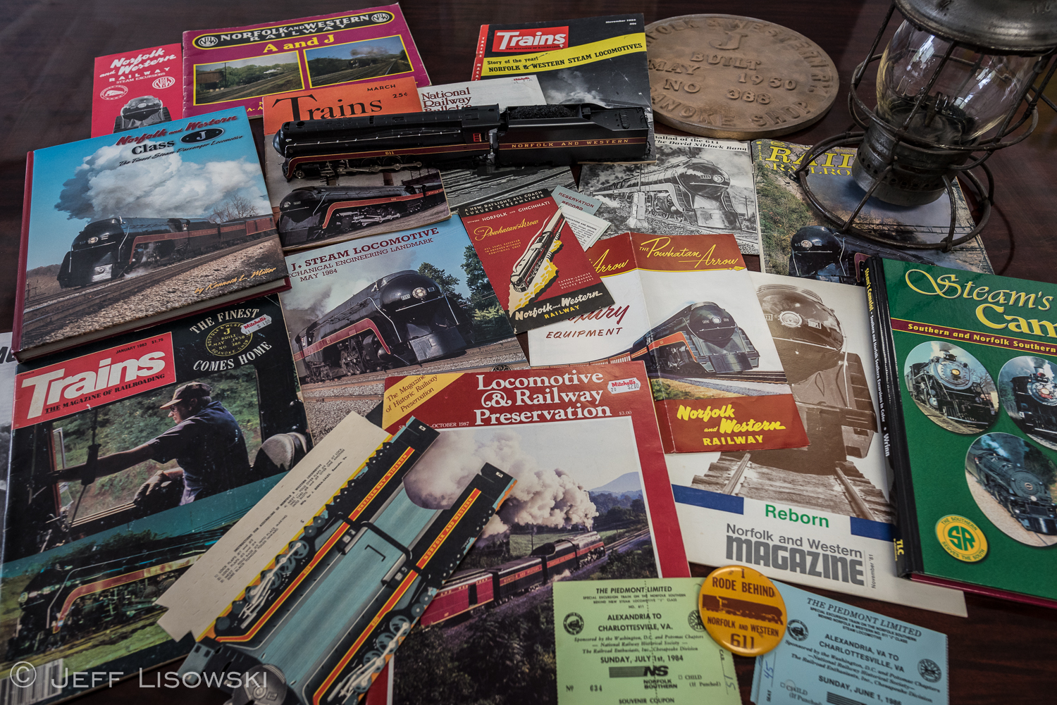 'J' class related memorabilia. Of special note; original March 1942 Trains magazine with the class leader #600 on cover, original 1949 Powhatan Arrow fold out brochure, original Powhatan Arrow ticket and sleeve, dated May 10, 1957, early 1940's cardboard model of 'J' class, David Niblock band 7" single "Ballad of the 611." 