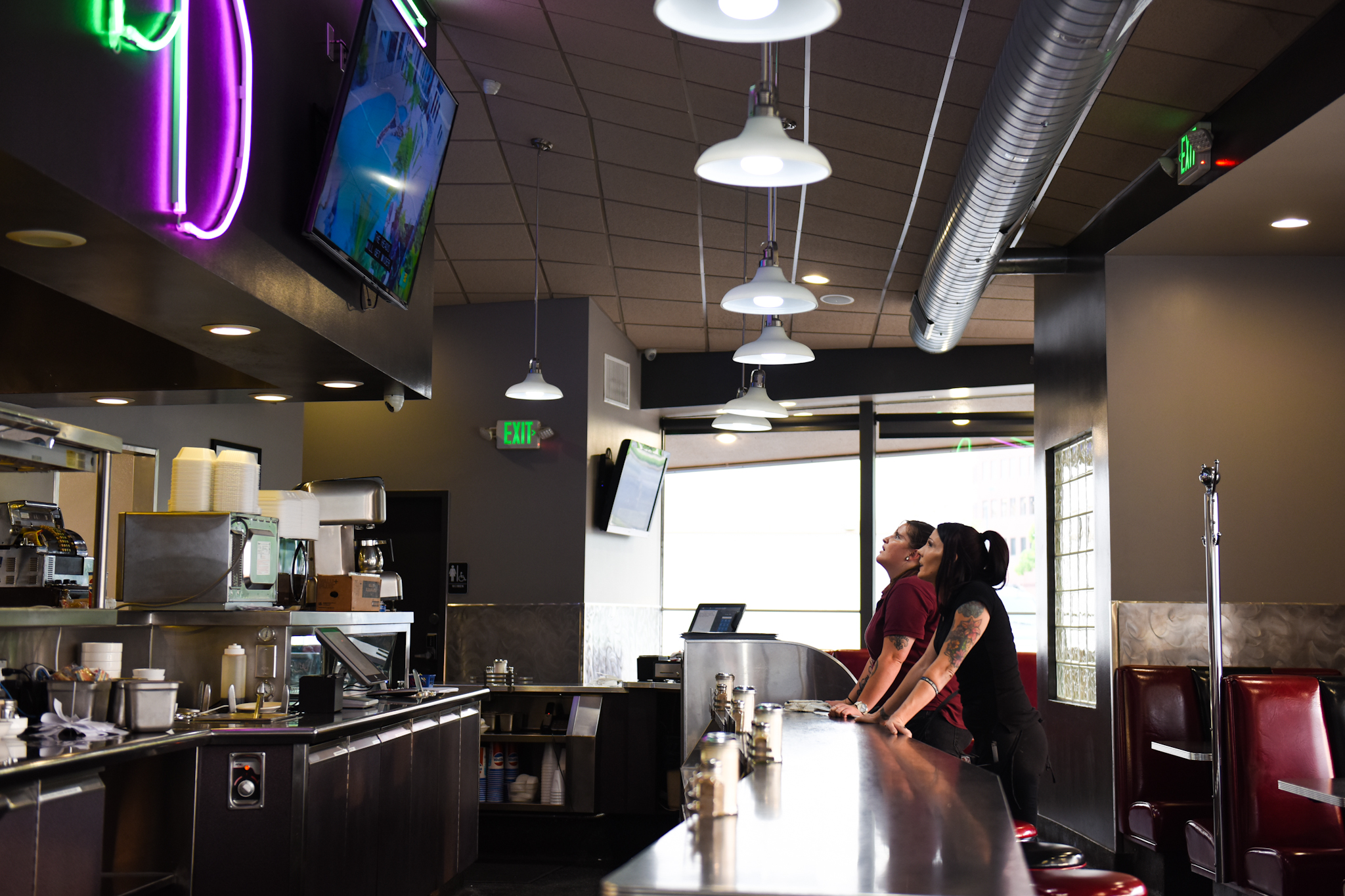 8 p.m.: Myrissa Adams, left, and Holliday watch one of two large TVs above the bar.