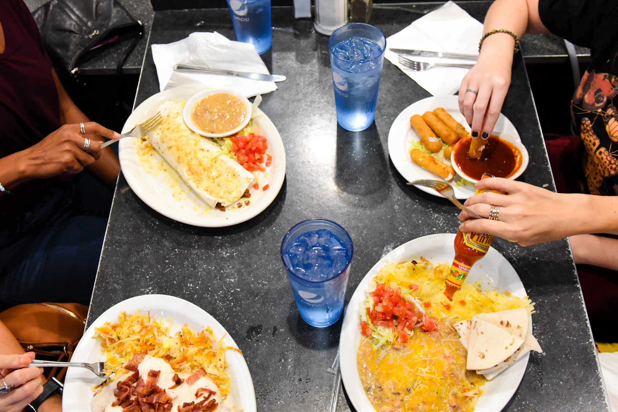 2 a.m.: Lauren Busher (back right), Jennifer Riley (front right), Lazarra Leonard (back left) and Liz McCarthy (front left) sit down for late-night food. Riley, the only one in the group who lives in Denver, says, "If we want food after 10 p.m., I know where we're going."