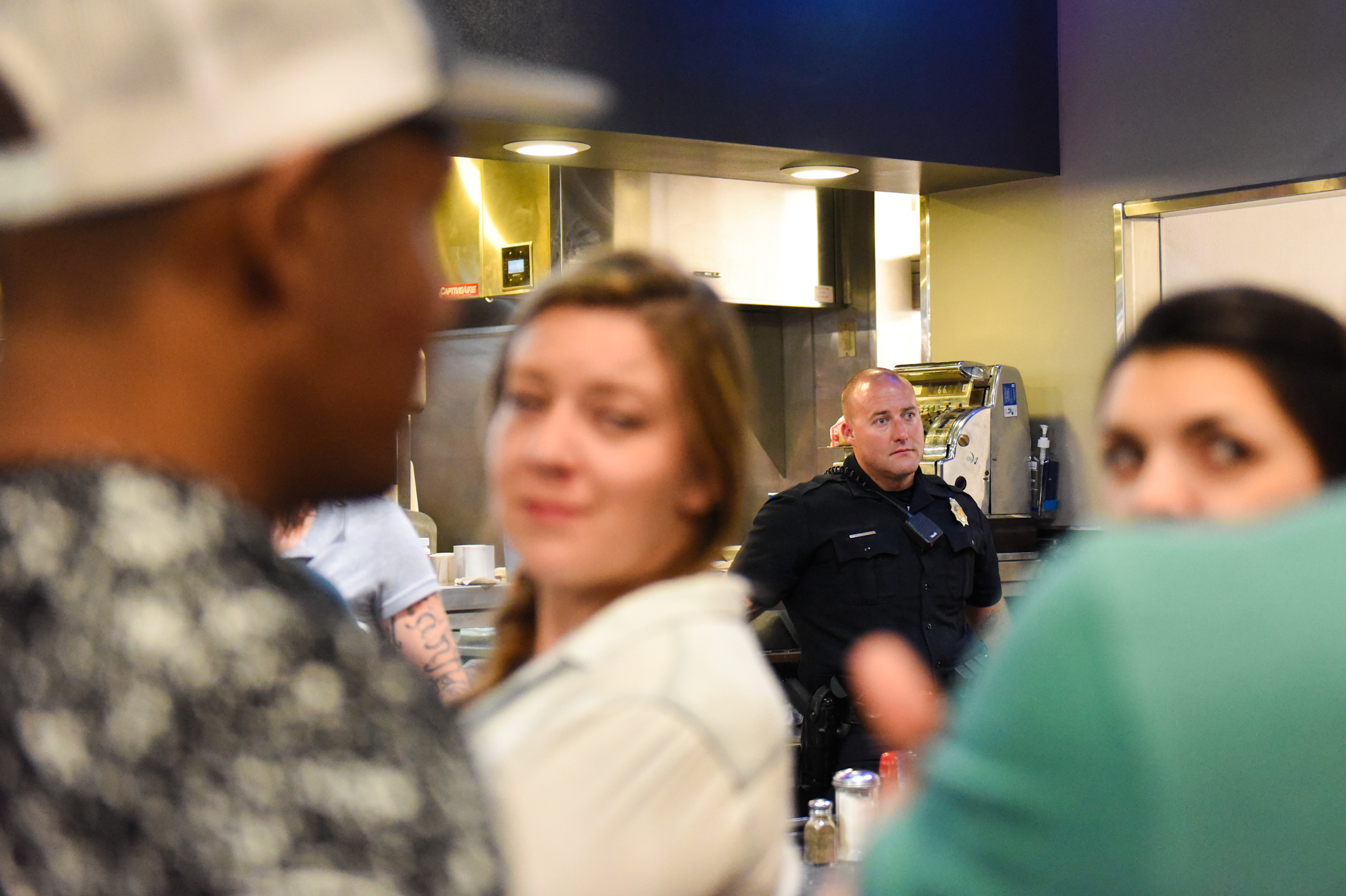 Officer Adam Foisy stands behind the counter at the Denver Diner. Every weekend, a police officer comes to the diner after midnight.
