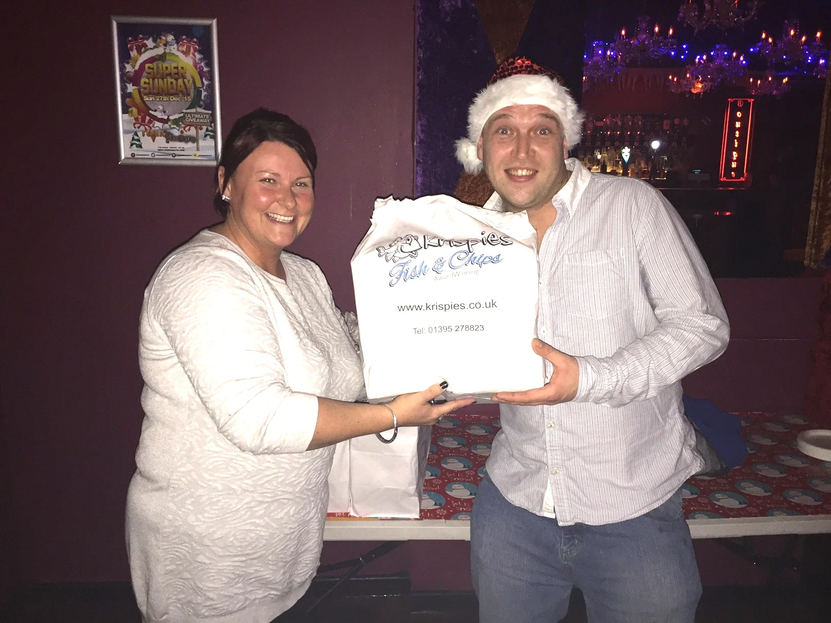 Kelly hands over one of 40 portions of Fish and Chips Krispies donated to the Spectrum charity event at Fever & Boutique nightclub in Exmouth