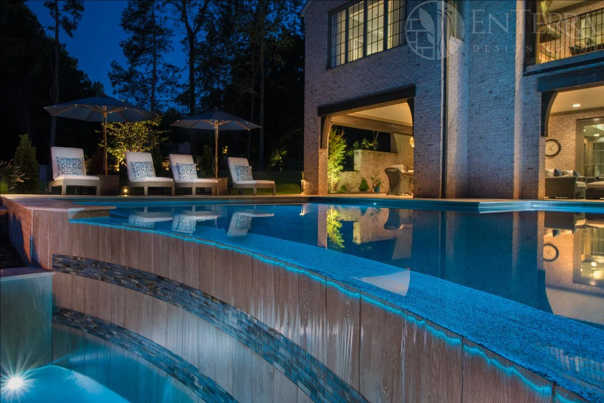 View from the fire pit patio of the vanishing edge spillway with alternating vertical "wood grain" & horizontal glass tile. 