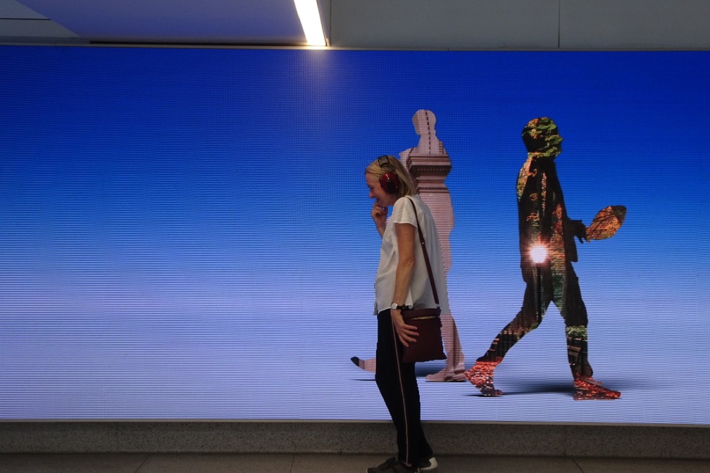 Kubisch pausing to listen in front of a giant LED display in Penn Station’s remodeled 8th-Avenue waiting area. photo credit: Christina Kubisch