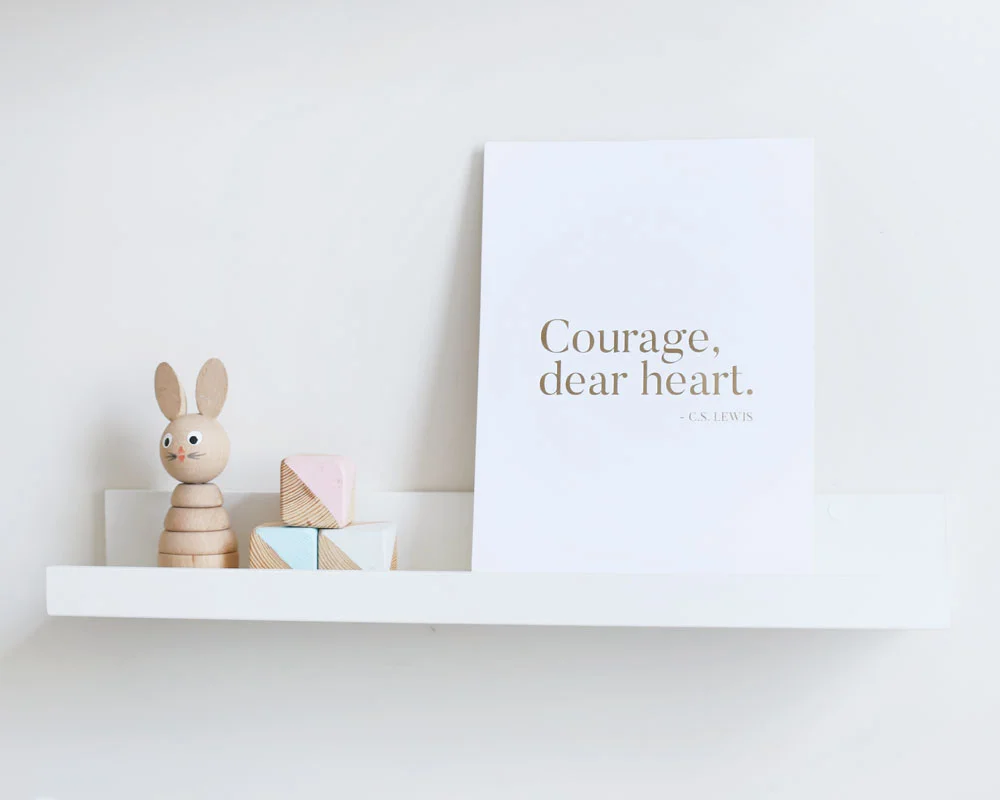 Courage, dear heart gold foiled print on shelf