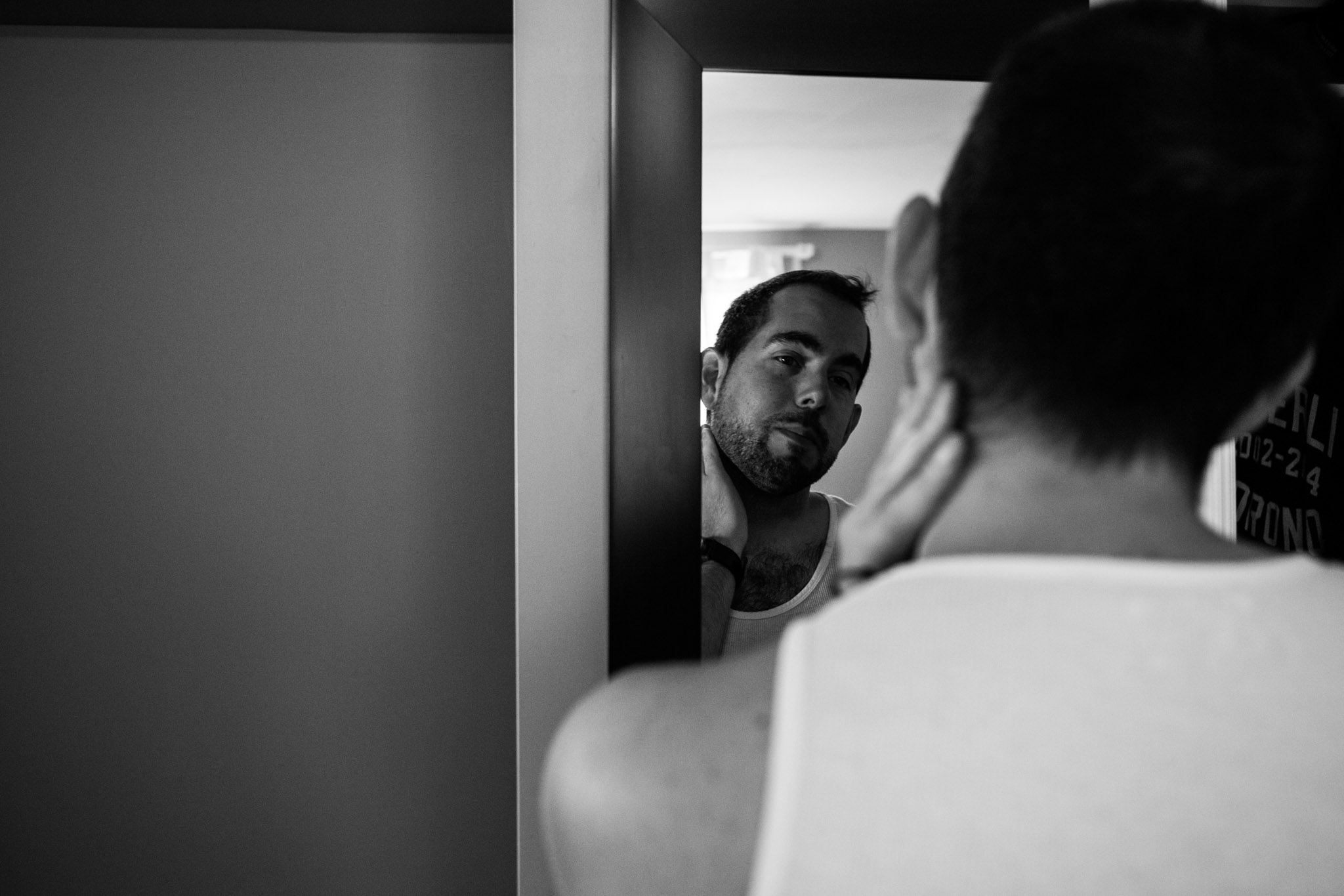 black and white wedding photography-groom reflected in mirror getting ready.jpg