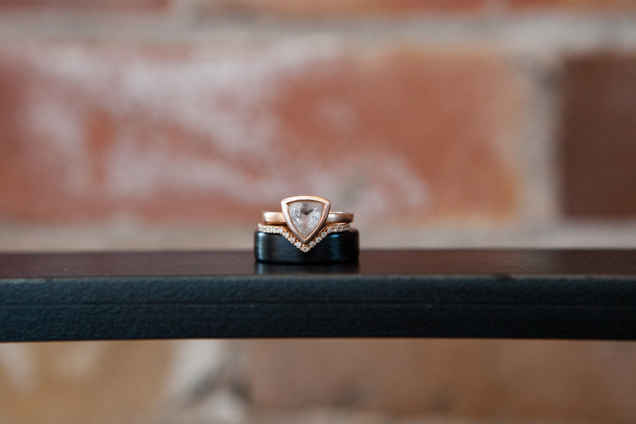 copper wedding rings single stone with red brick wall - wedding photography.jpg