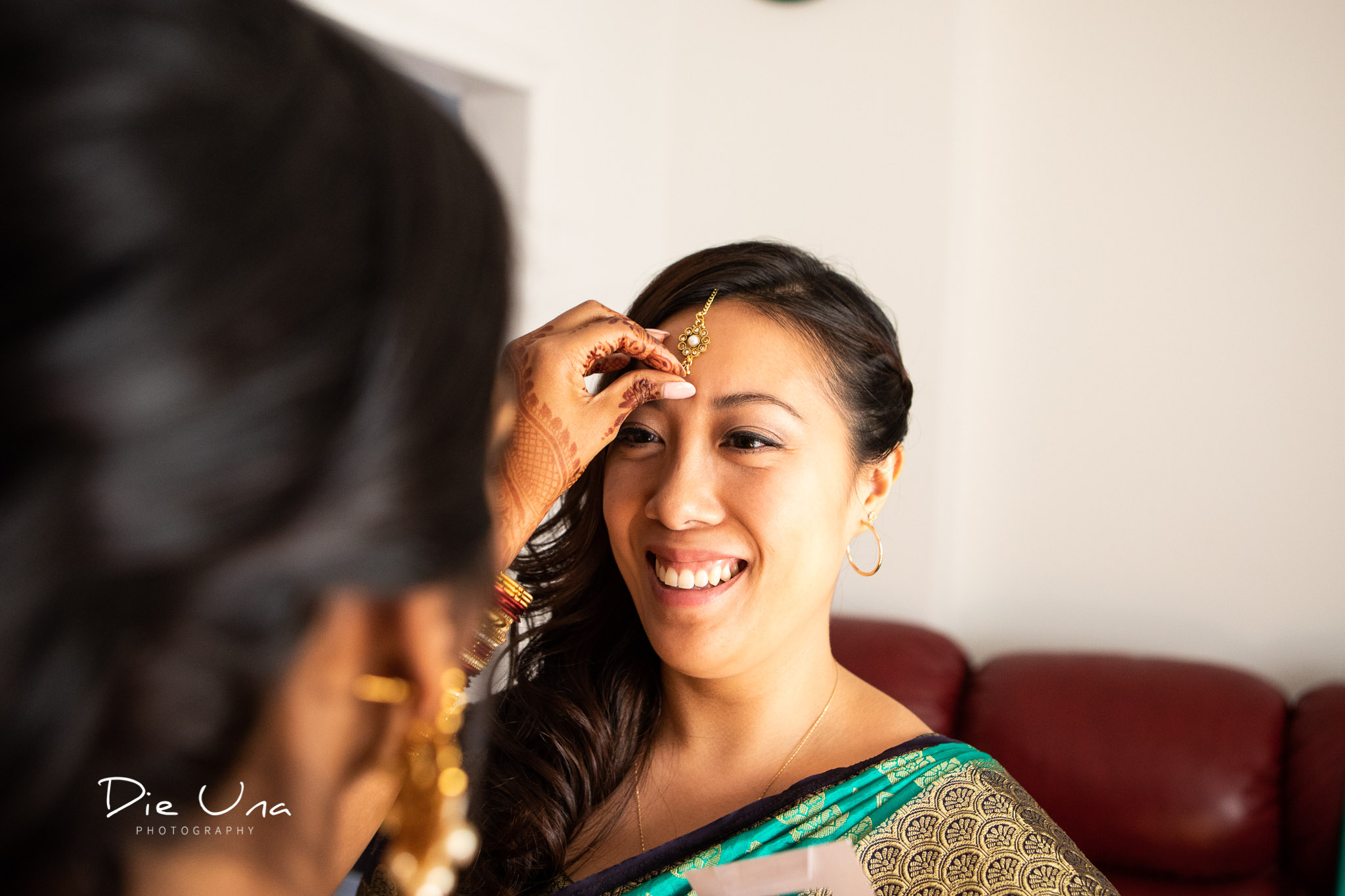 bride putting a bindi on a bridesmaid .jpg