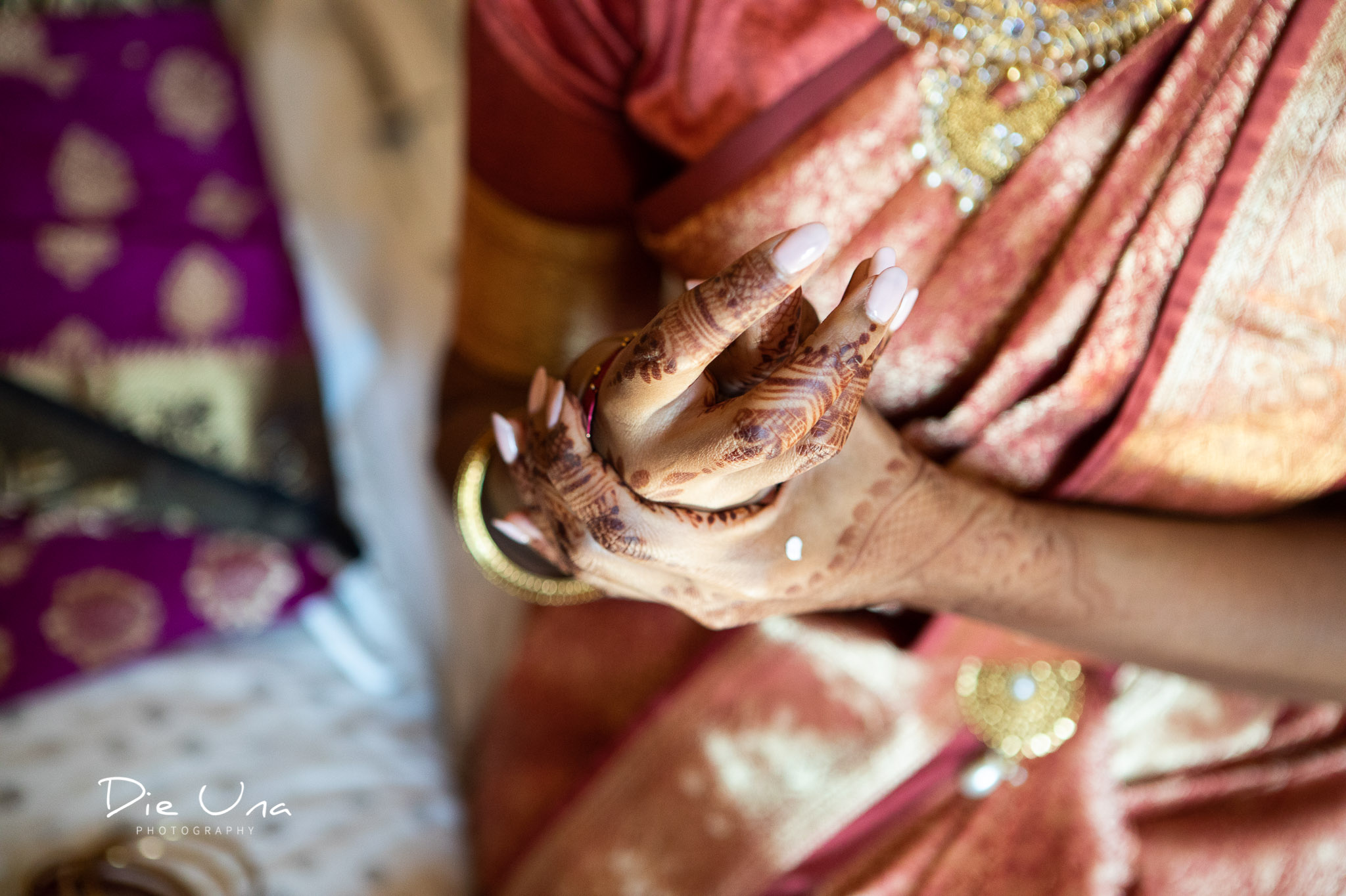 bride putting on wedding bracelets while wearing saree.jpg
