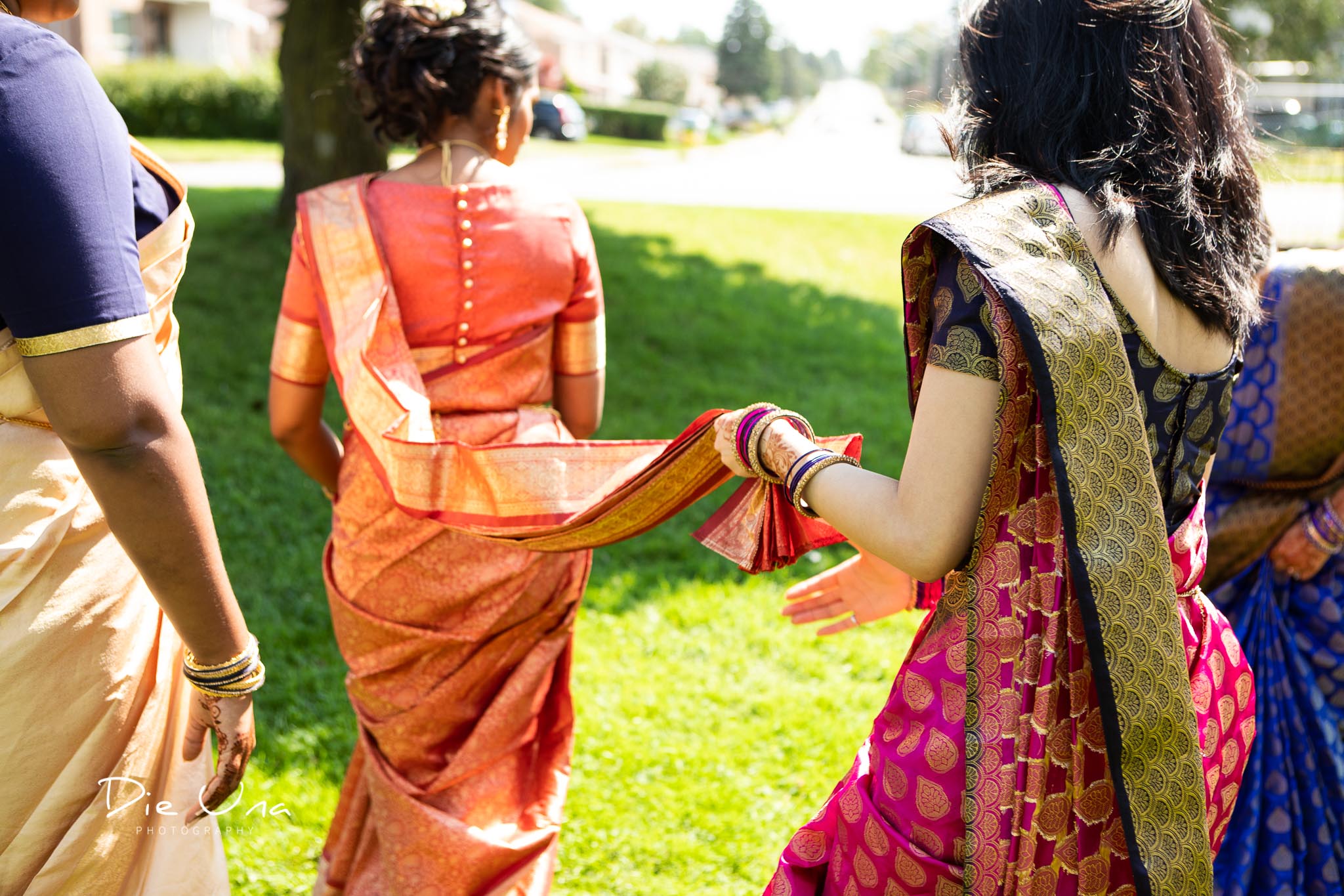 bride walking while bridesmaid holds saree.jpg