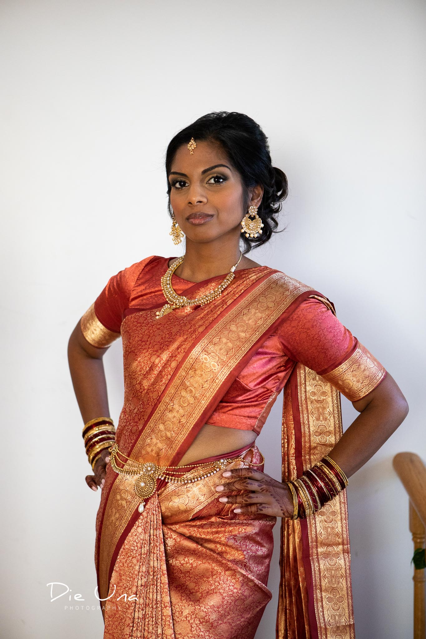 bride wearing red and gold saree.jpg