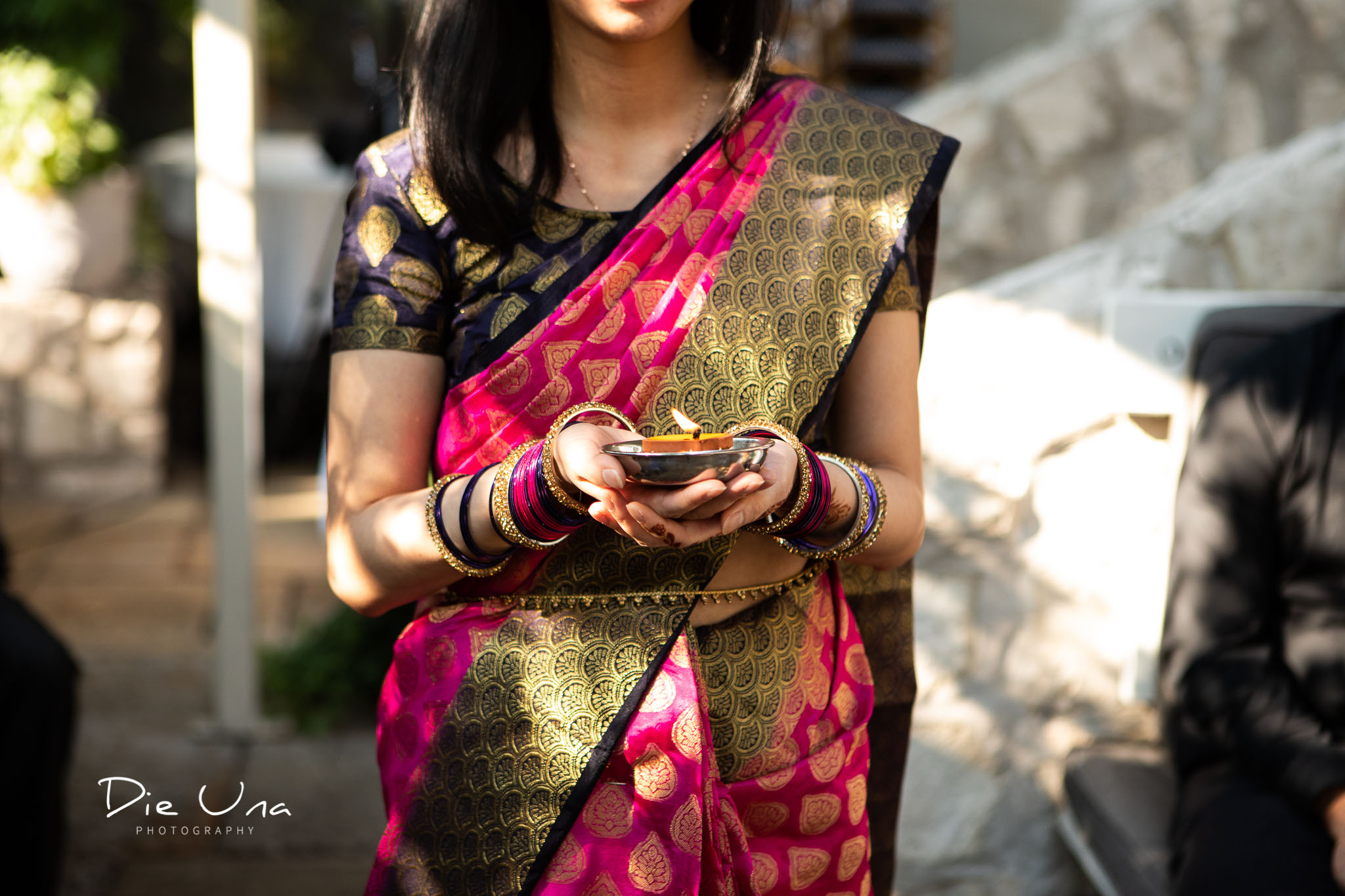 bridesmaid wearing saree carrying candle down the aisle.jpg