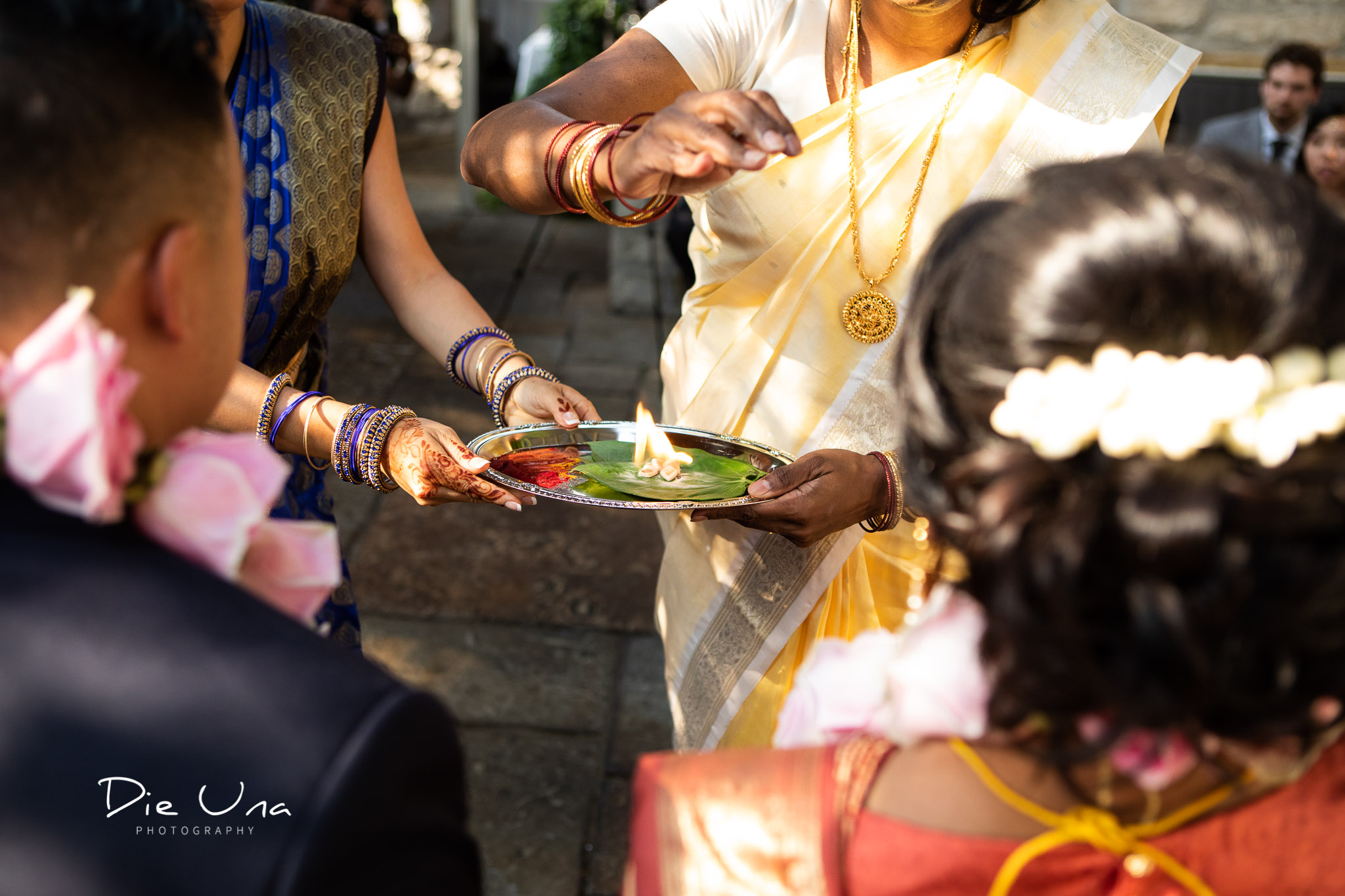 close up of tray with red powder and flame to bless the bride and groom during Hindu wedding.jpg